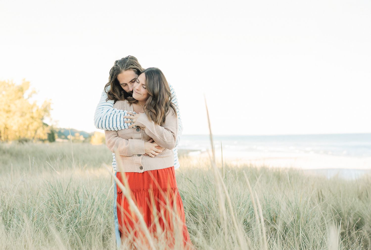 wife with husband holding her in the dunes Bridgman, MI