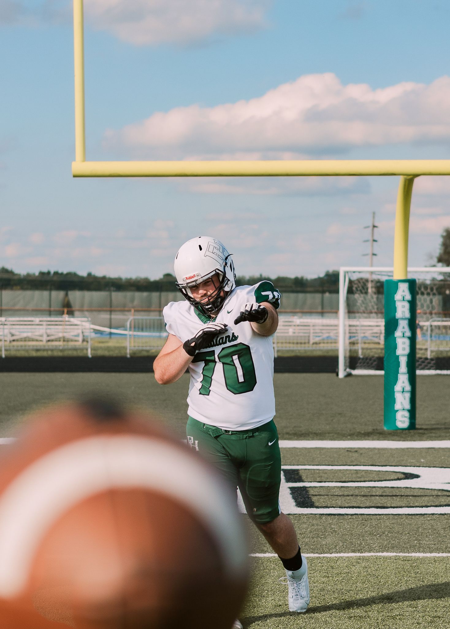 high school football player throwing football