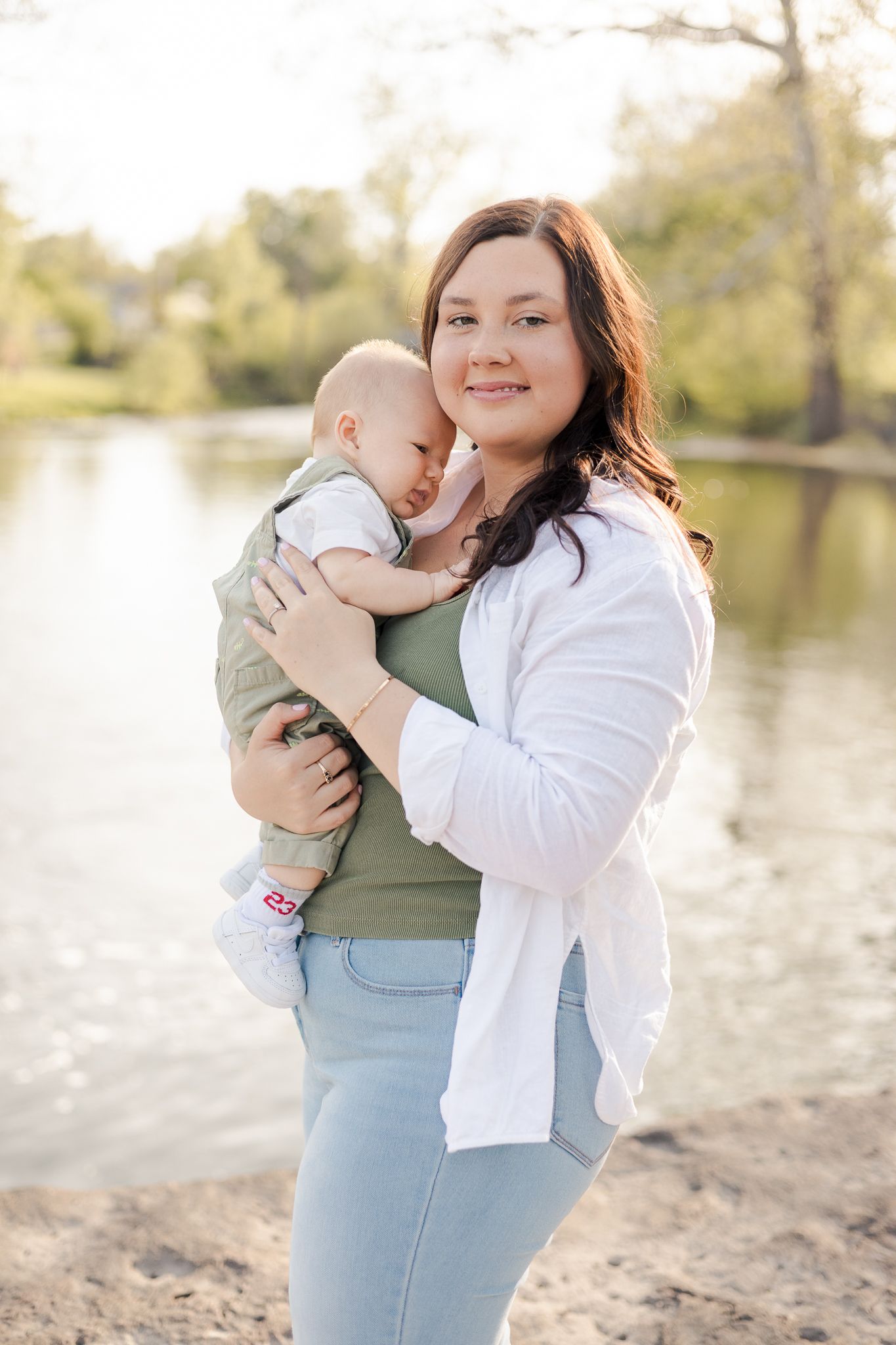 mother holding baby next to a pond in Pendleton, IN