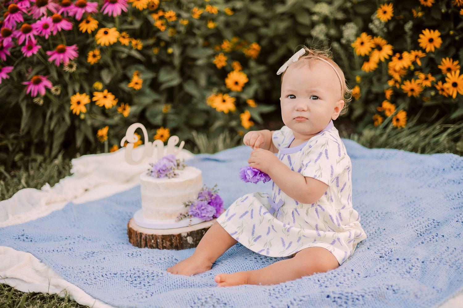 baby first birthday cake smash surrounded by beautiful flowers