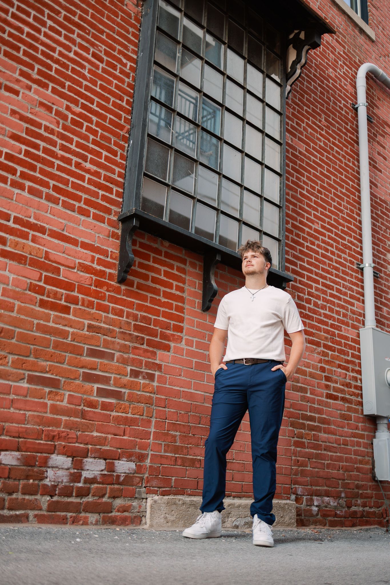 senior standing in front of a red brick building