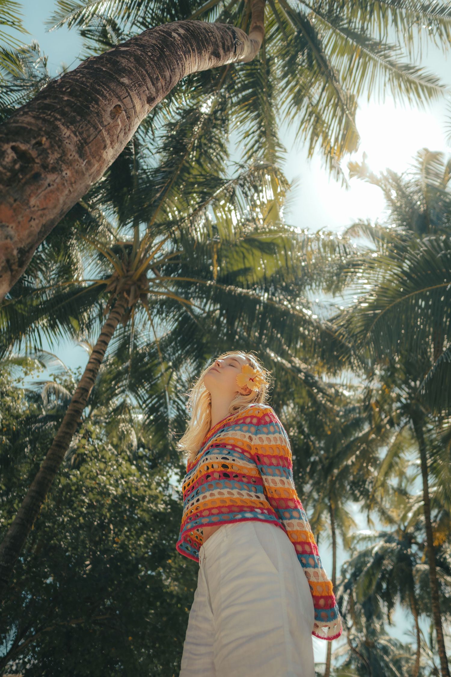Palm trees sway against a bright sky in a tropical paradise setting.