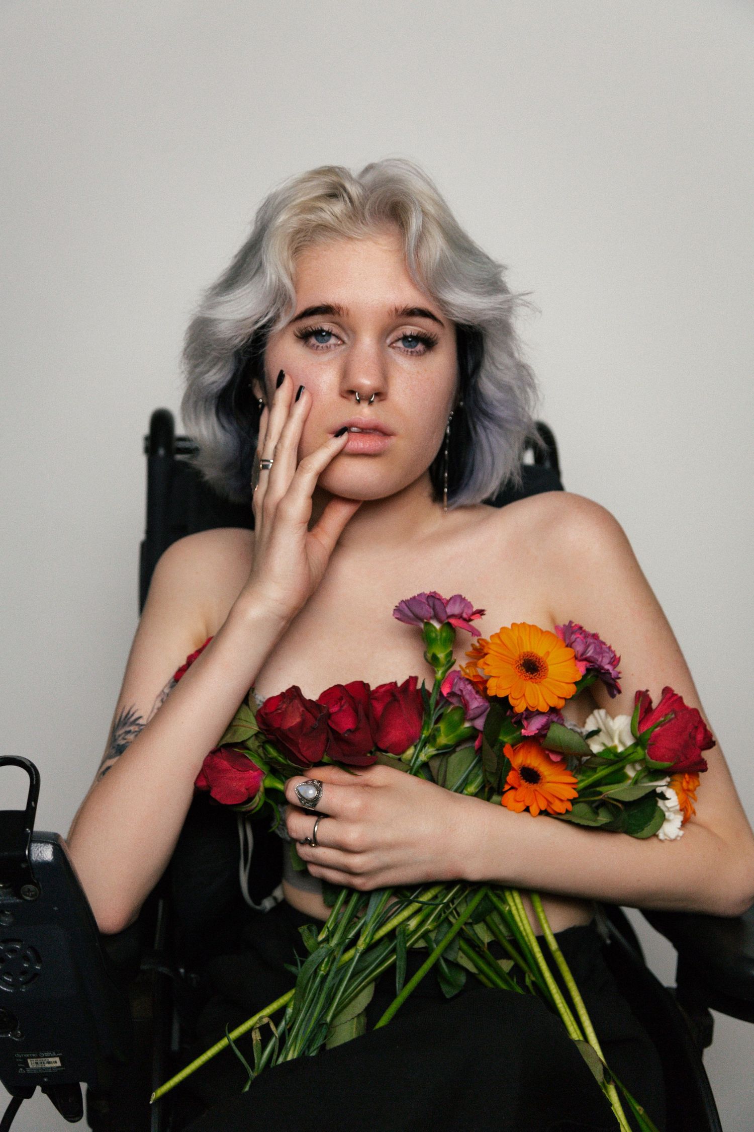 Artistic photo series with colorful flowers and silver hair against dark background.