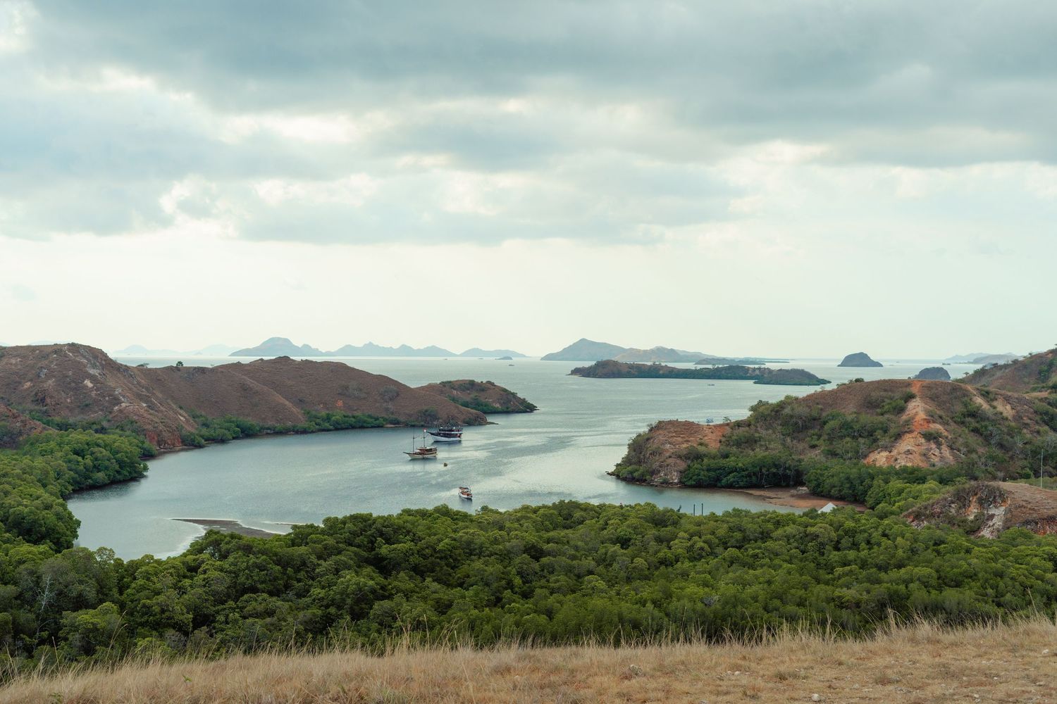 Panoramic view of rugged coastal mountains and islands surrounded by blue ocean waters.