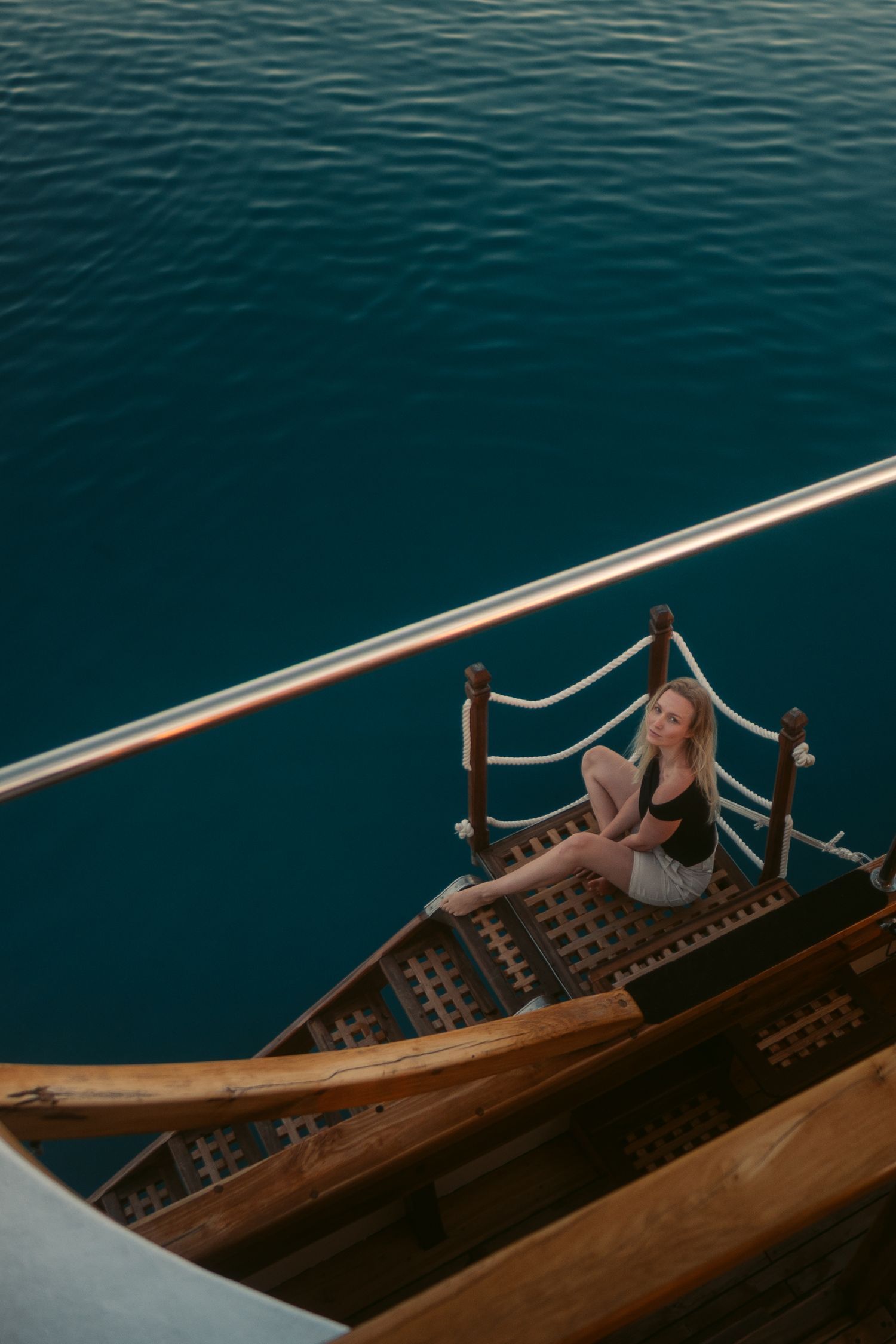 Wooden boat deck scene with deep blue water and relaxing maritime atmosphere.