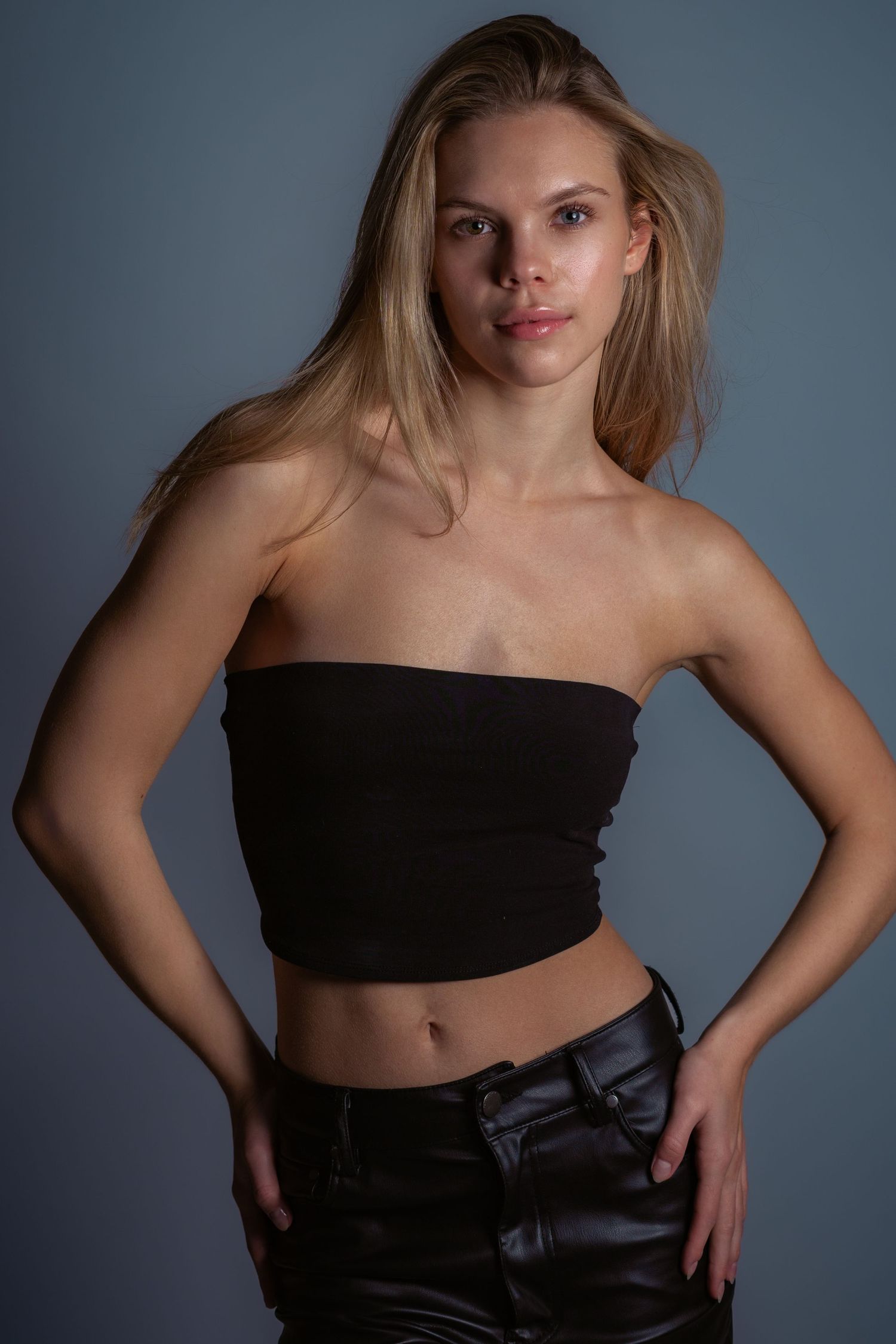Fashion portrait series in black clothing against grey studio backdrop.