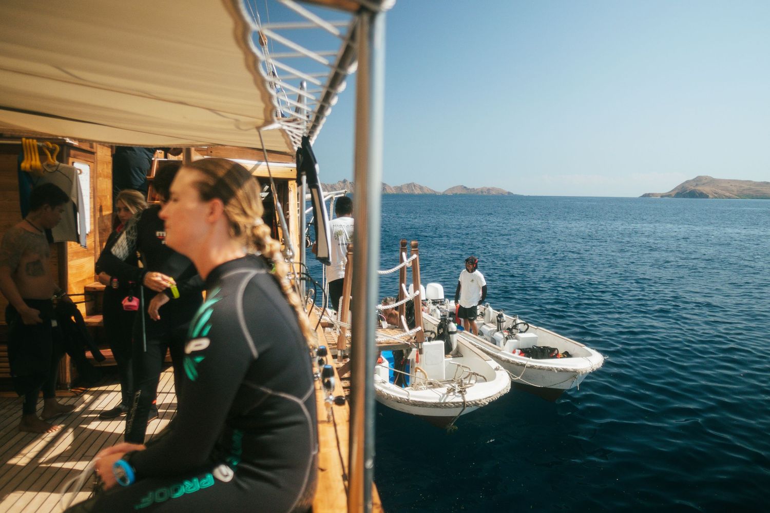 People enjoying views from deck of sailing yacht on bright sunny day at sea.