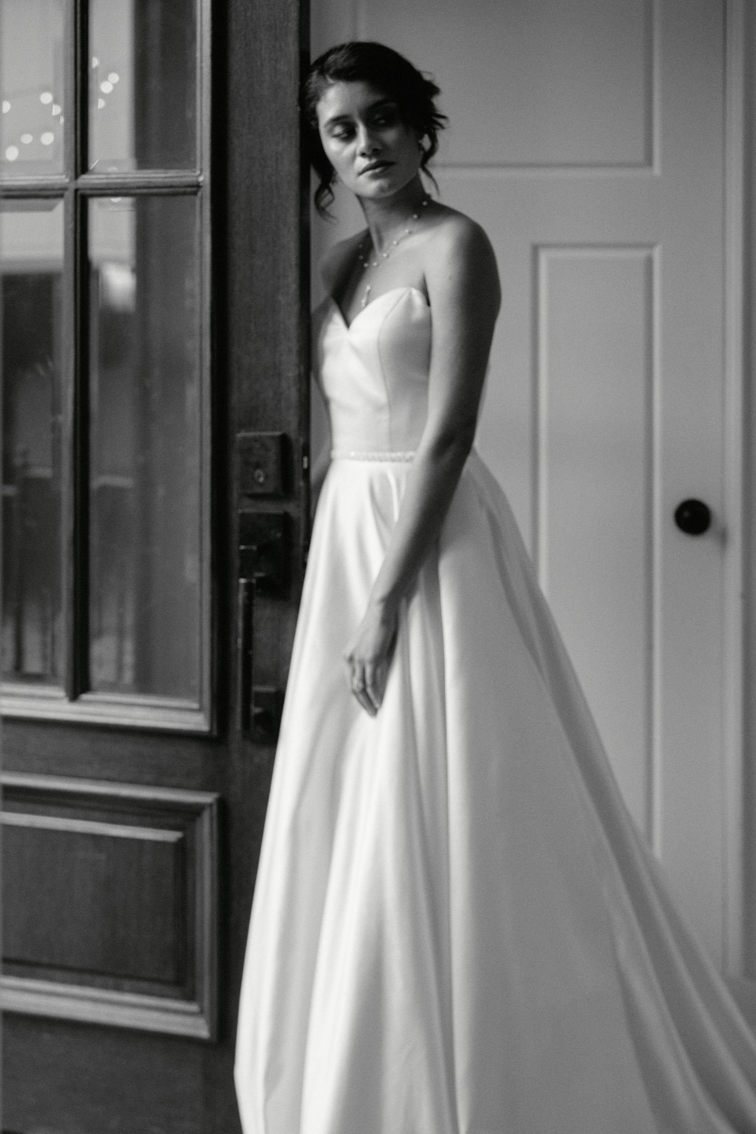 Black and white portrait of a bride in a classic ballgown style wedding dress.