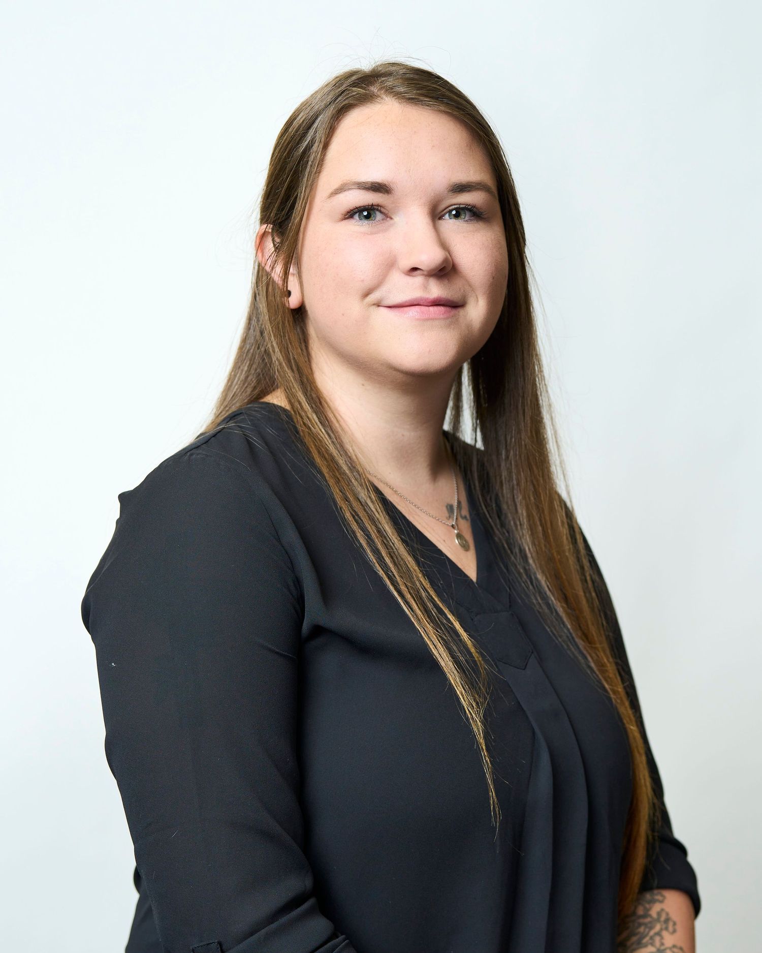 Professional headshot in Asheville of a nursing student sitting in front of a white seamless.