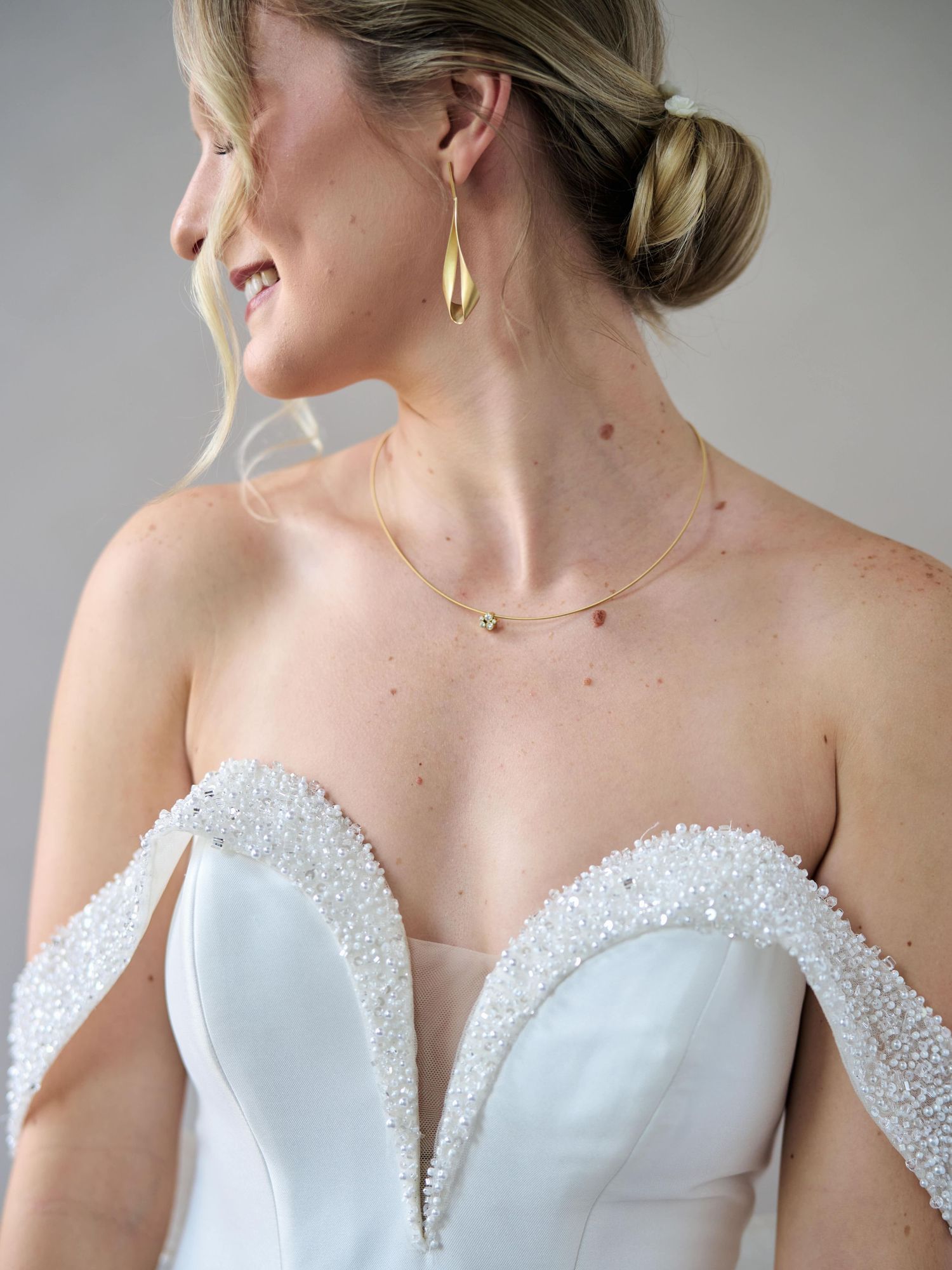 Elegant bridal jewelry with gold drop earrings and beaded sweetheart neckline dress.