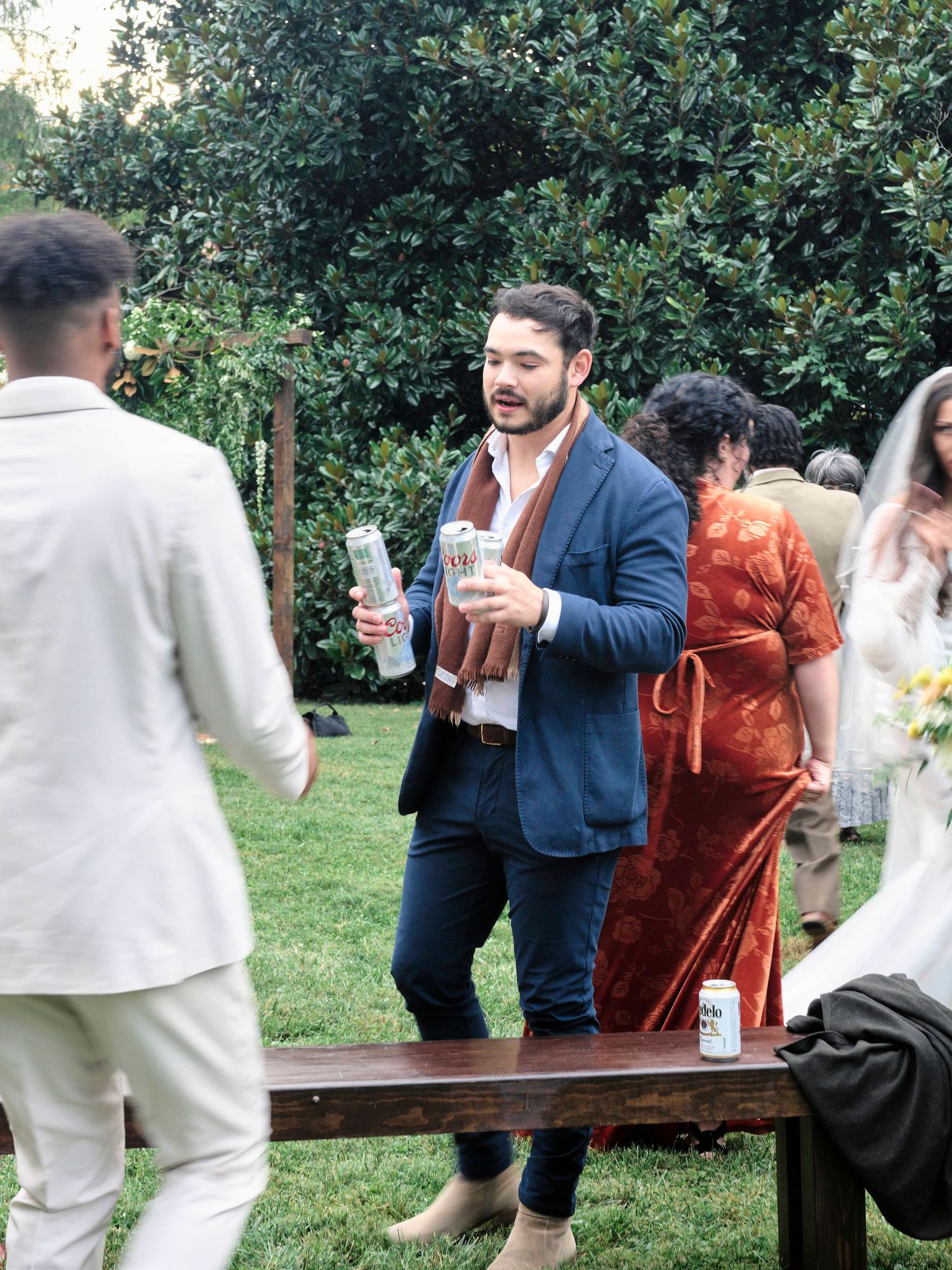 Wedding guests socialize and enjoy drinks during an outdoor reception.