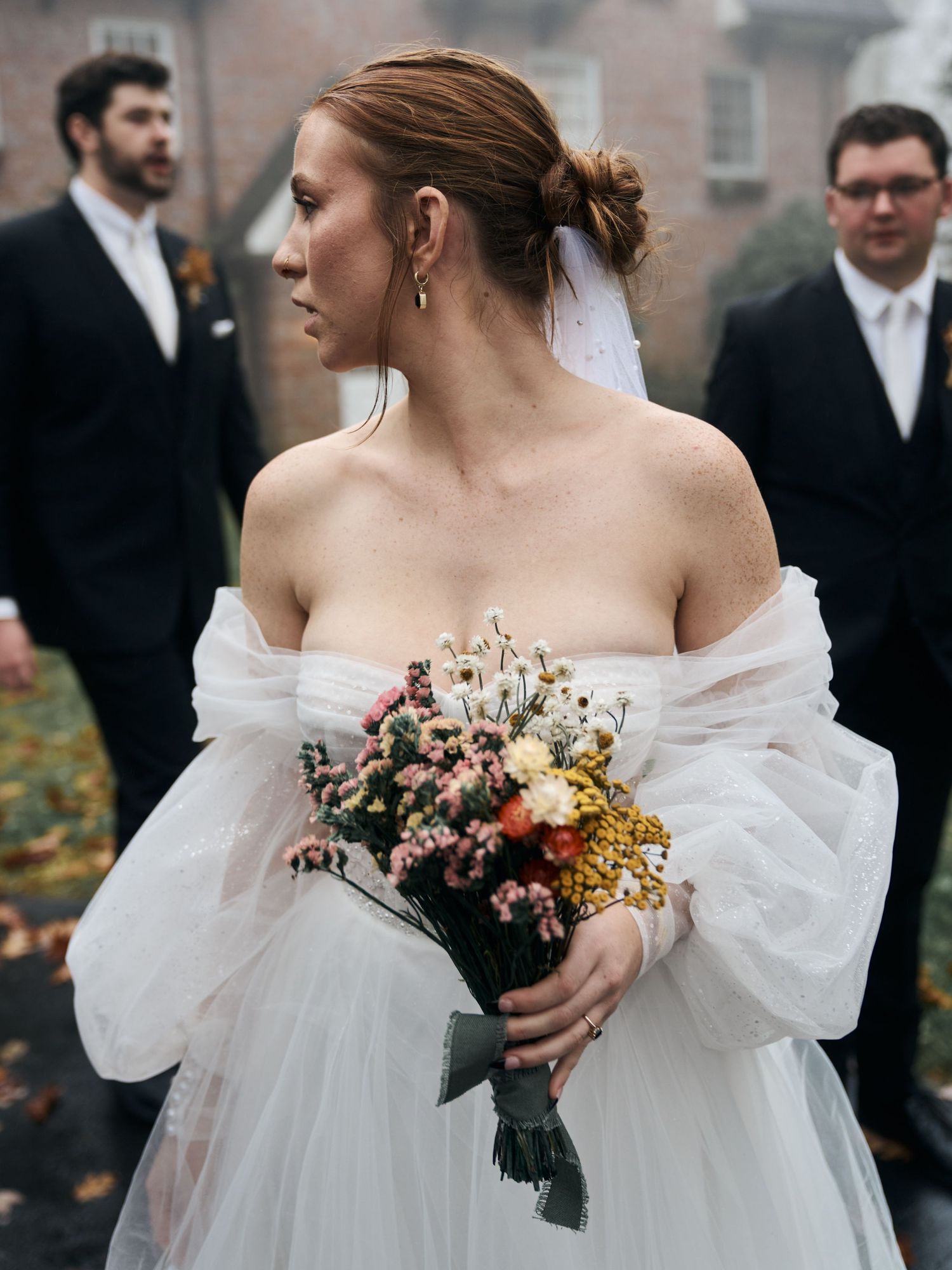 Bride with autumn bouquet poses in ethereal off-shoulder gown.