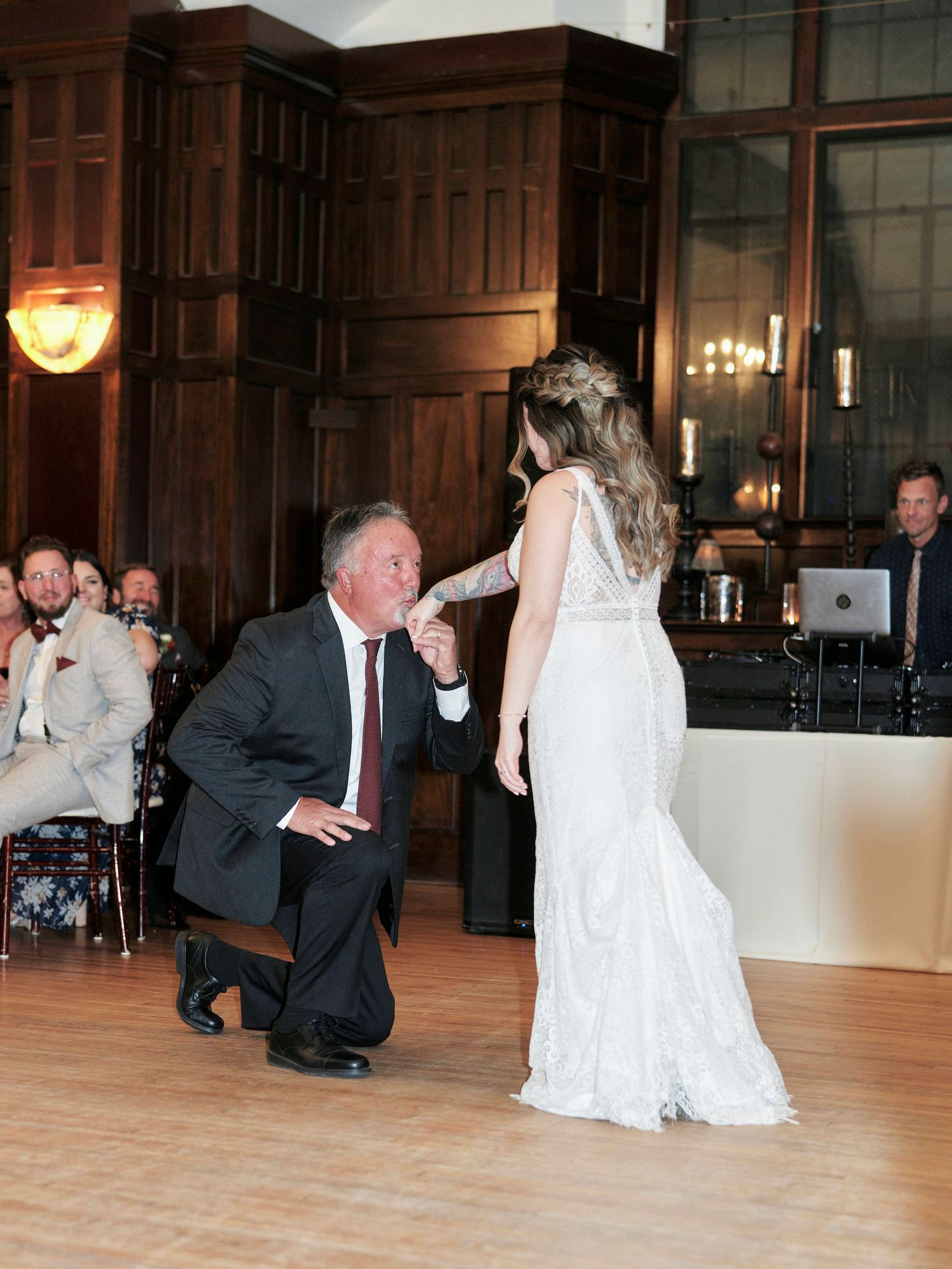 A touching father-daughter dance moment on the wooden dance floor at an elegant wedding reception.