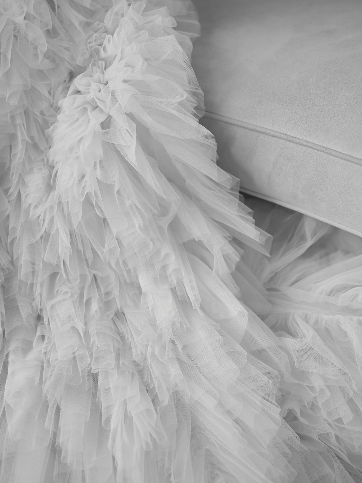 Close-up detail of white tulle layers on wedding dress creating dramatic texture.