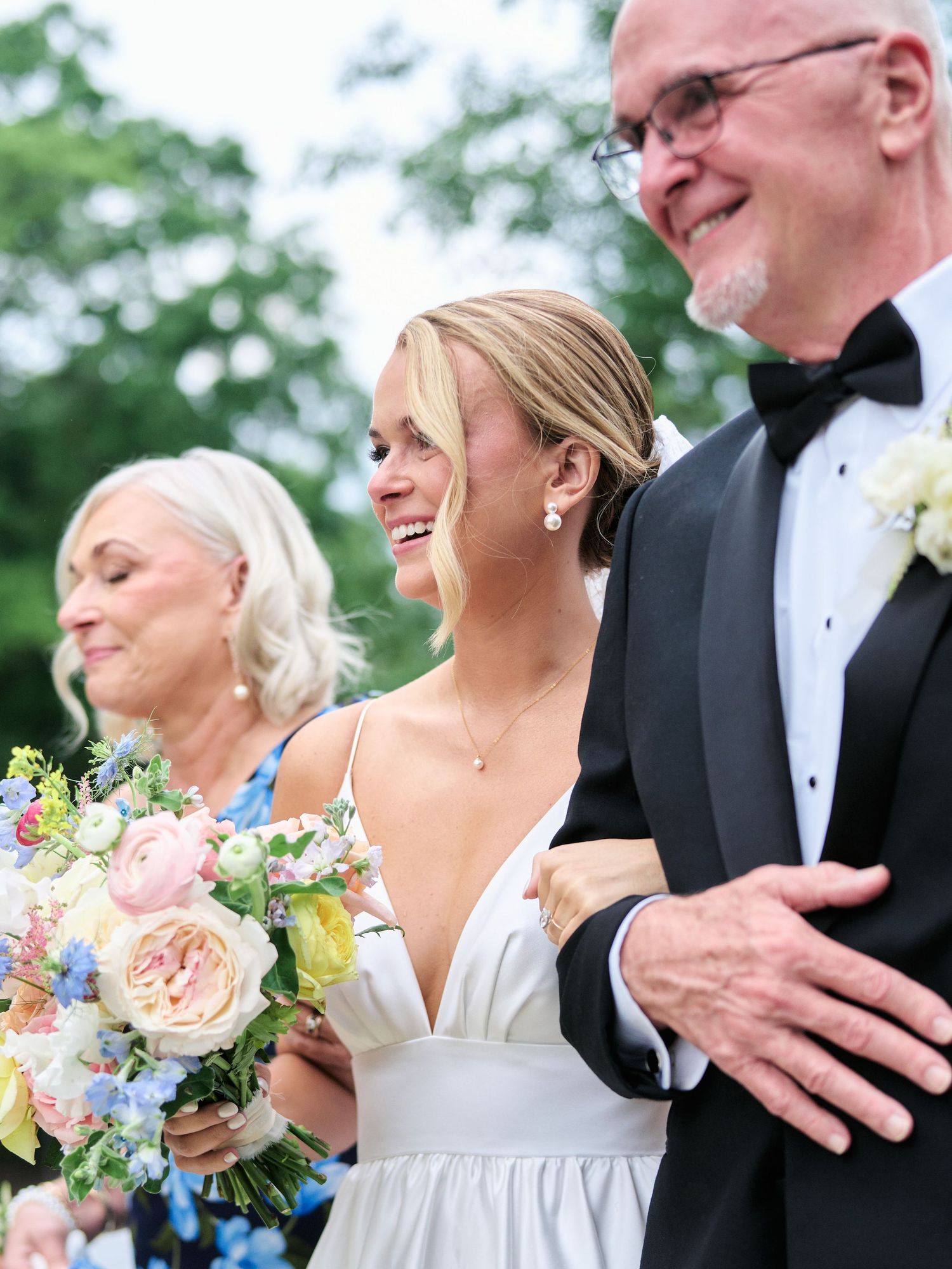 Joyful wedding moment outdoors with beautiful spring bouquet featuring pastel flowers.
