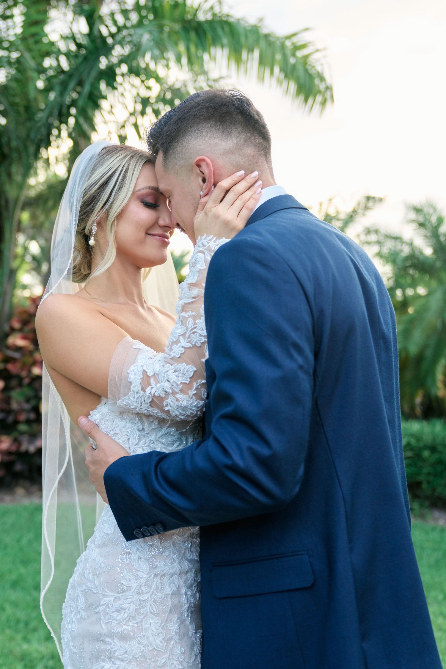 Tender embrace between newlyweds in a tropical garden setting.