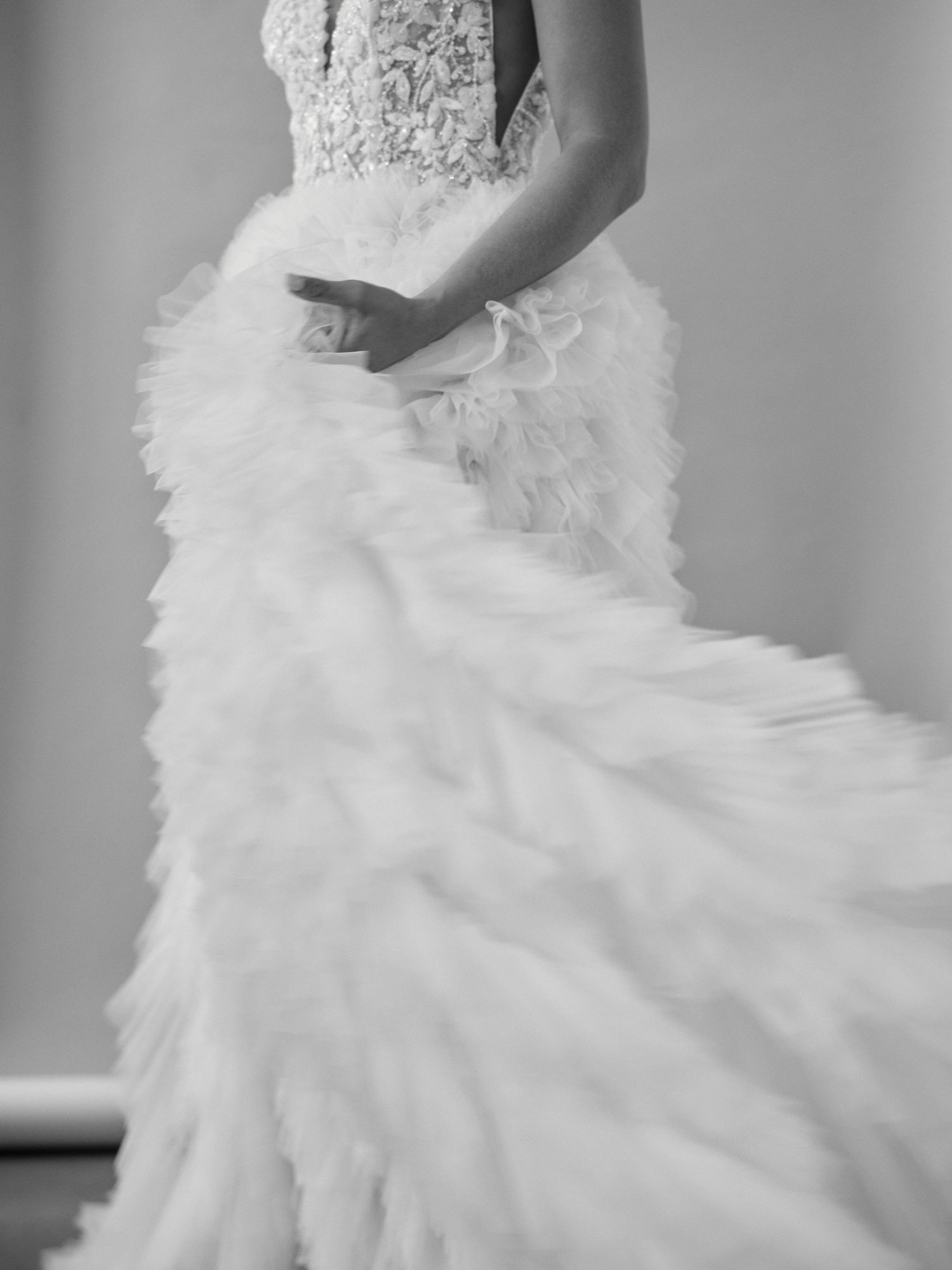 Detail shot of a luxurious white wedding dress with ruffled tulle layers.