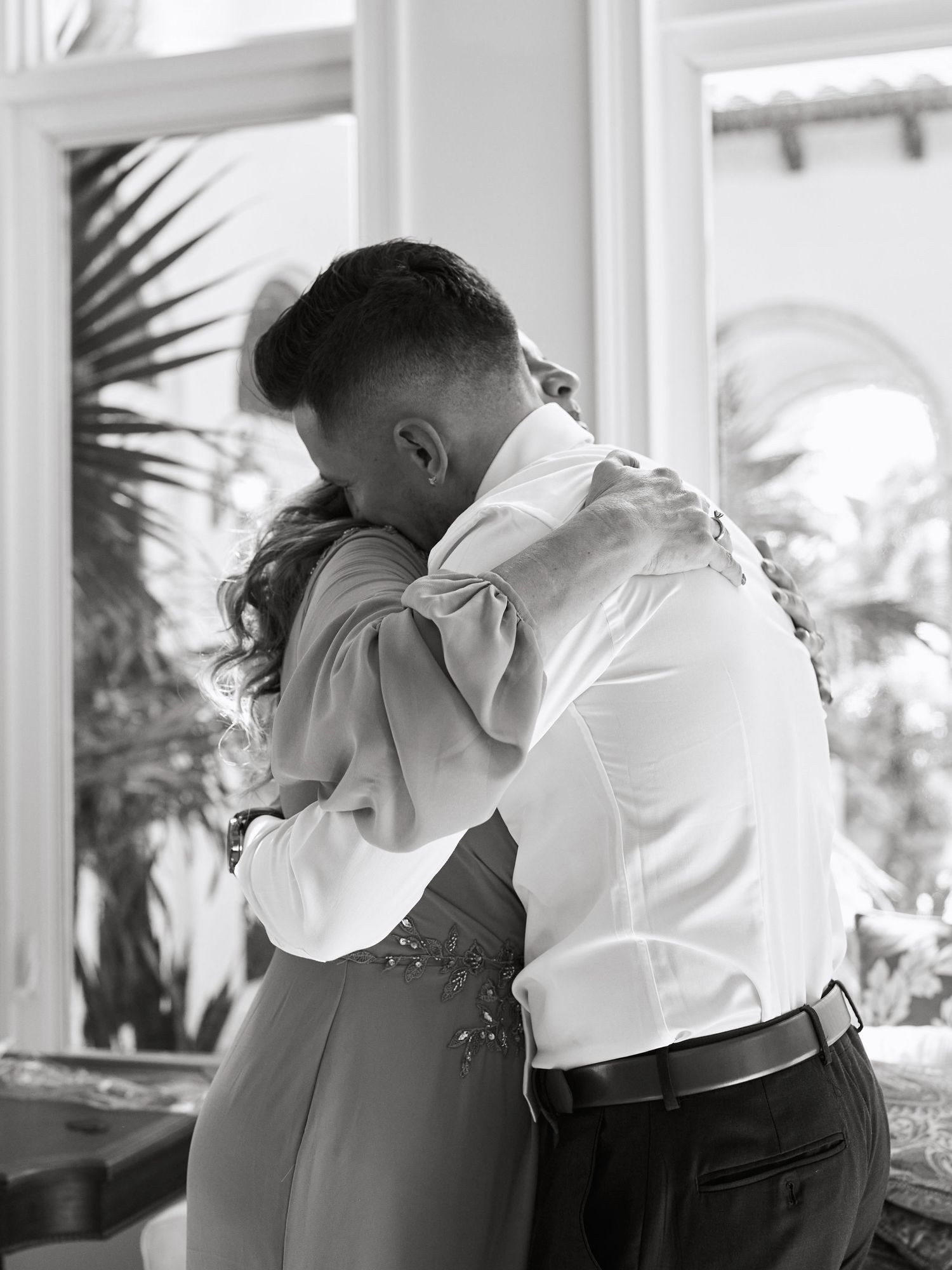 Black and white photo of intimate embrace during wedding celebration.