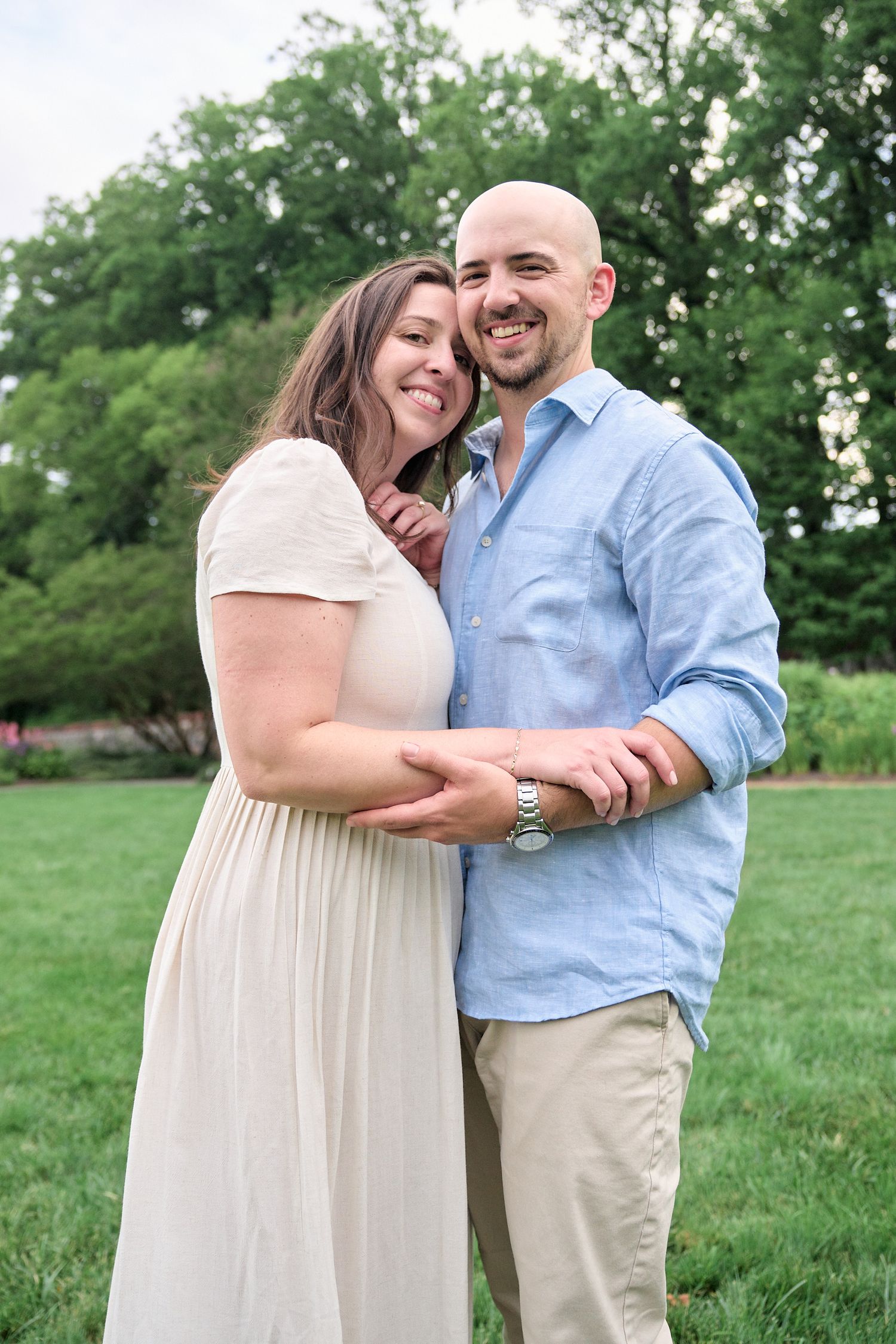 A romantic moment captured in a garden setting with natural greenery.