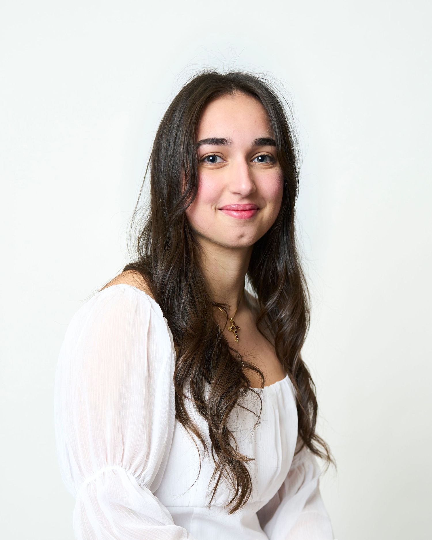 Professional headshot of a student sitting in a studio in front of a white backdrop.