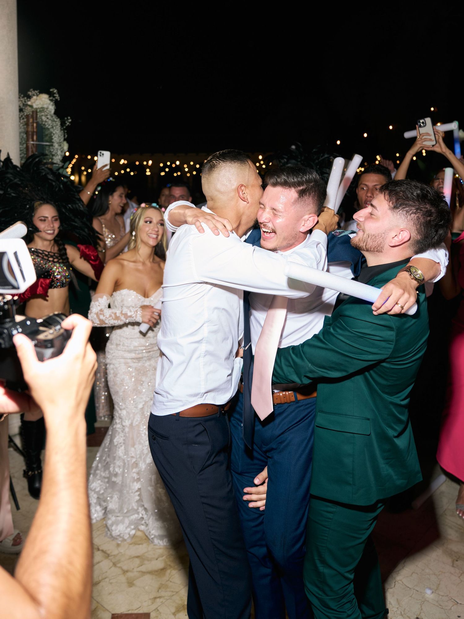 Celebratory moment at wedding reception with crowd cheering and taking photos.