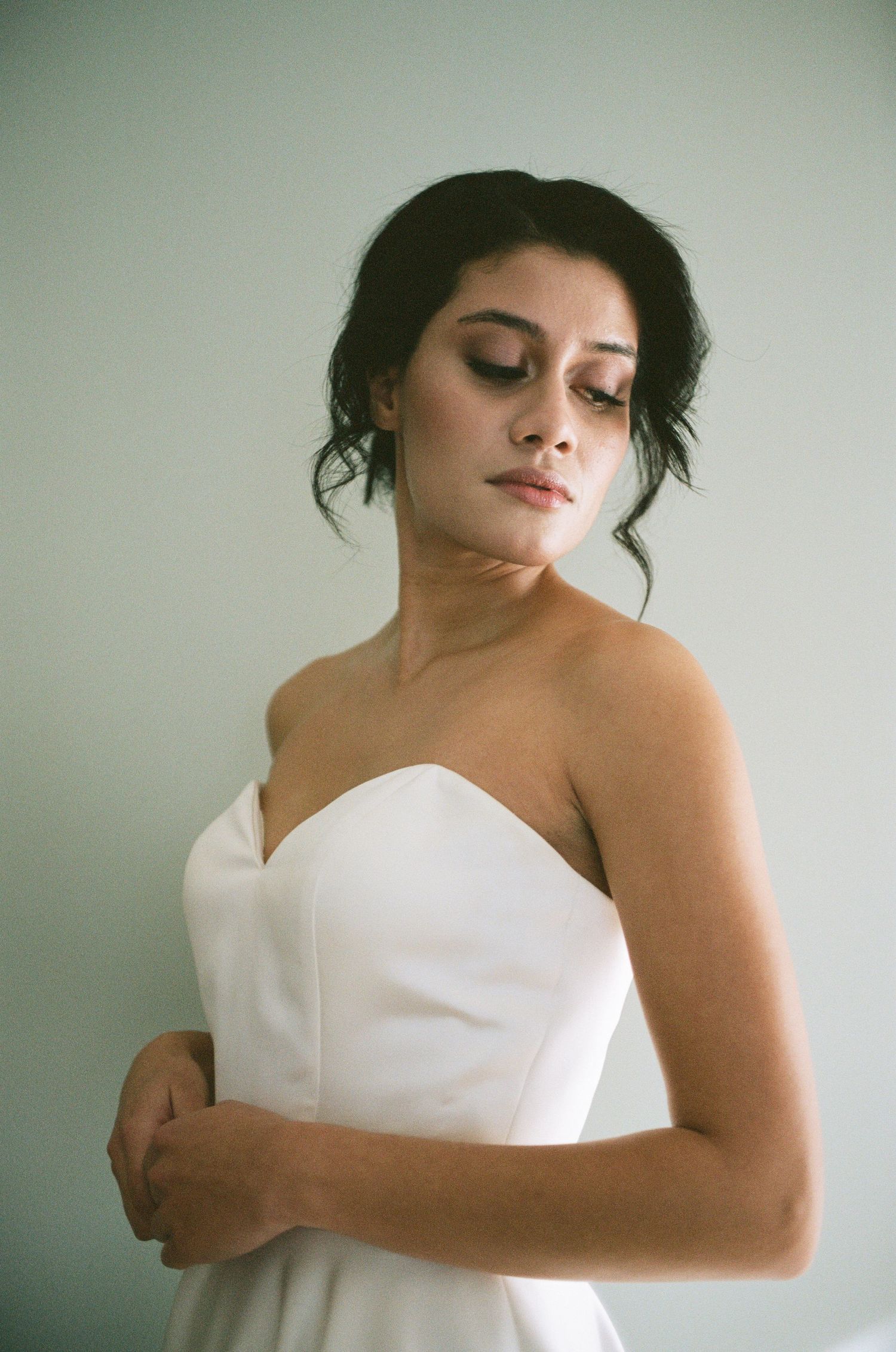Bride looking down at her dress as she's getting ready for her wedding