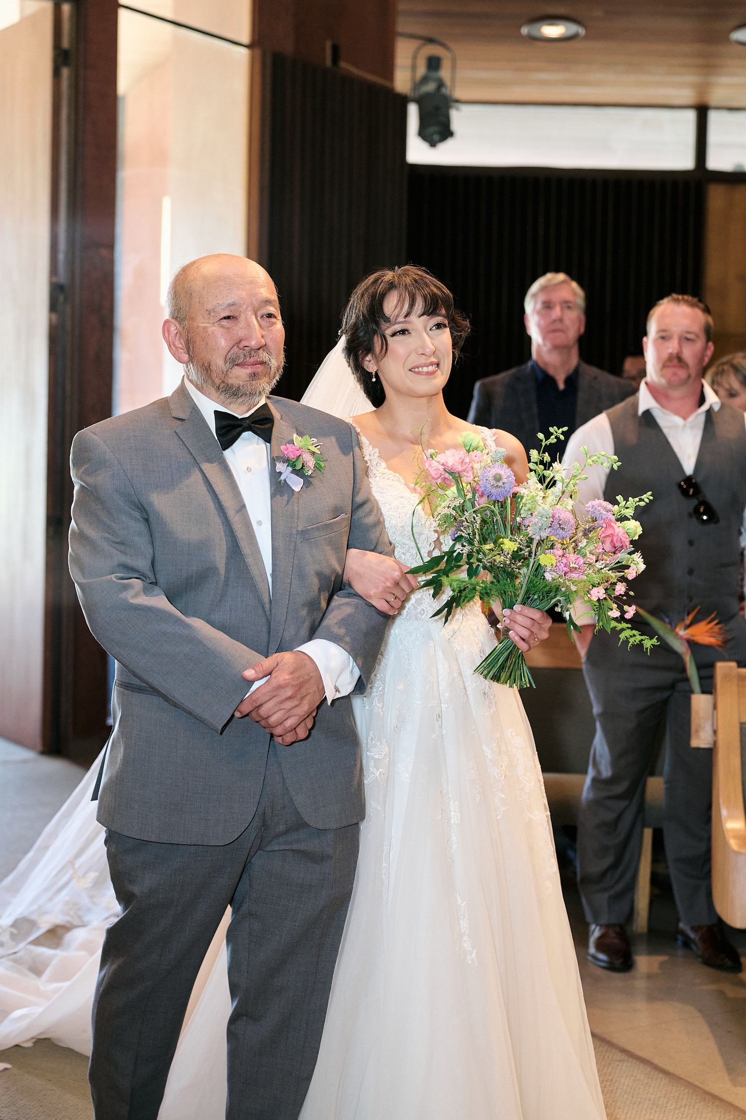 A traditional wedding processional scene with elegant floral bouquet and formal attire.