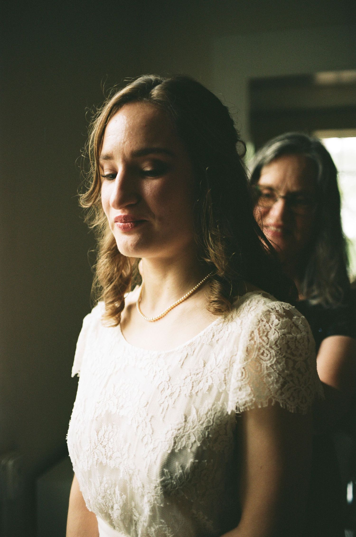 Soft lighting creates an intimate portrait in delicate lace and pearls.