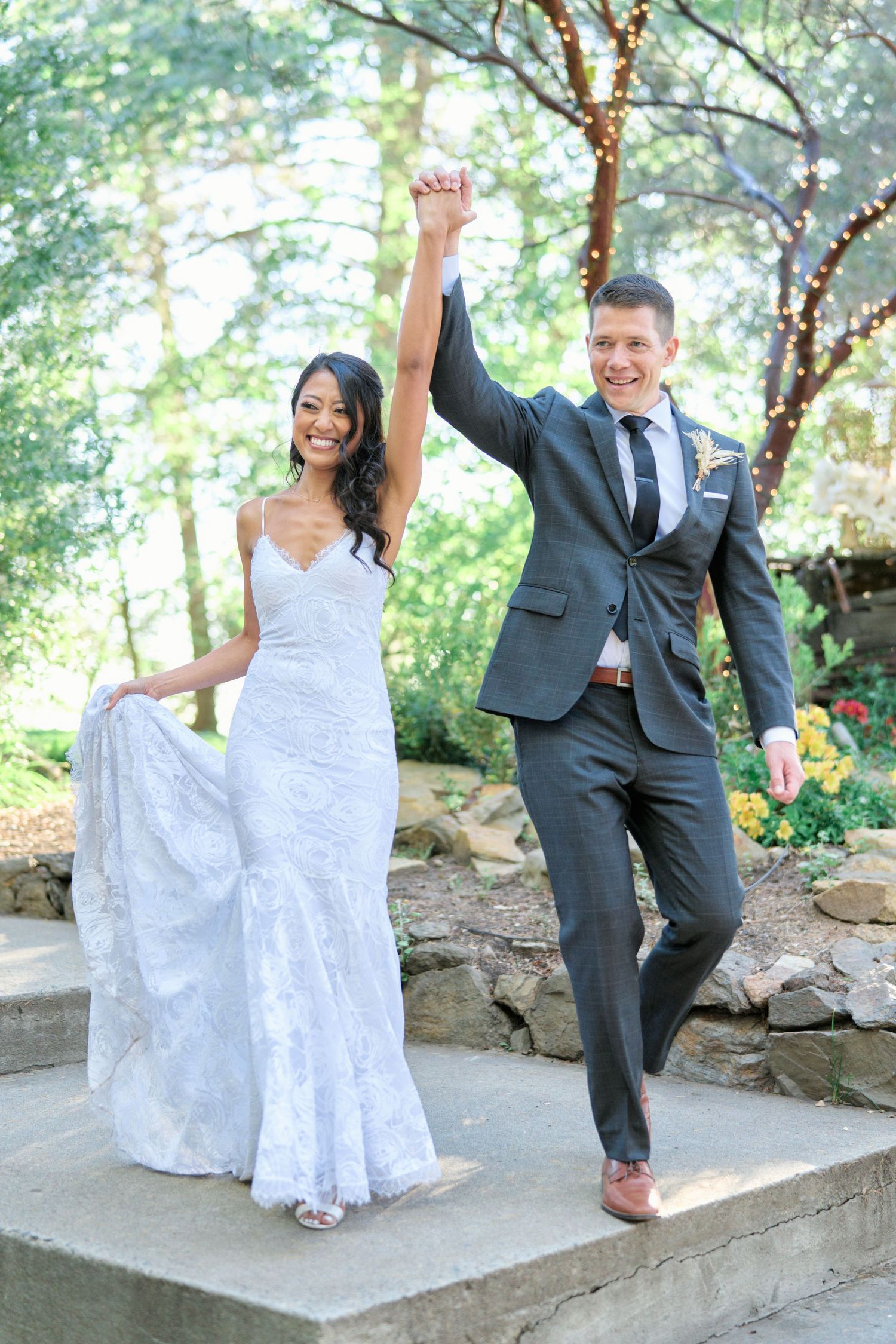 A celebratory moment on outdoor stone steps surrounded by lush greenery.