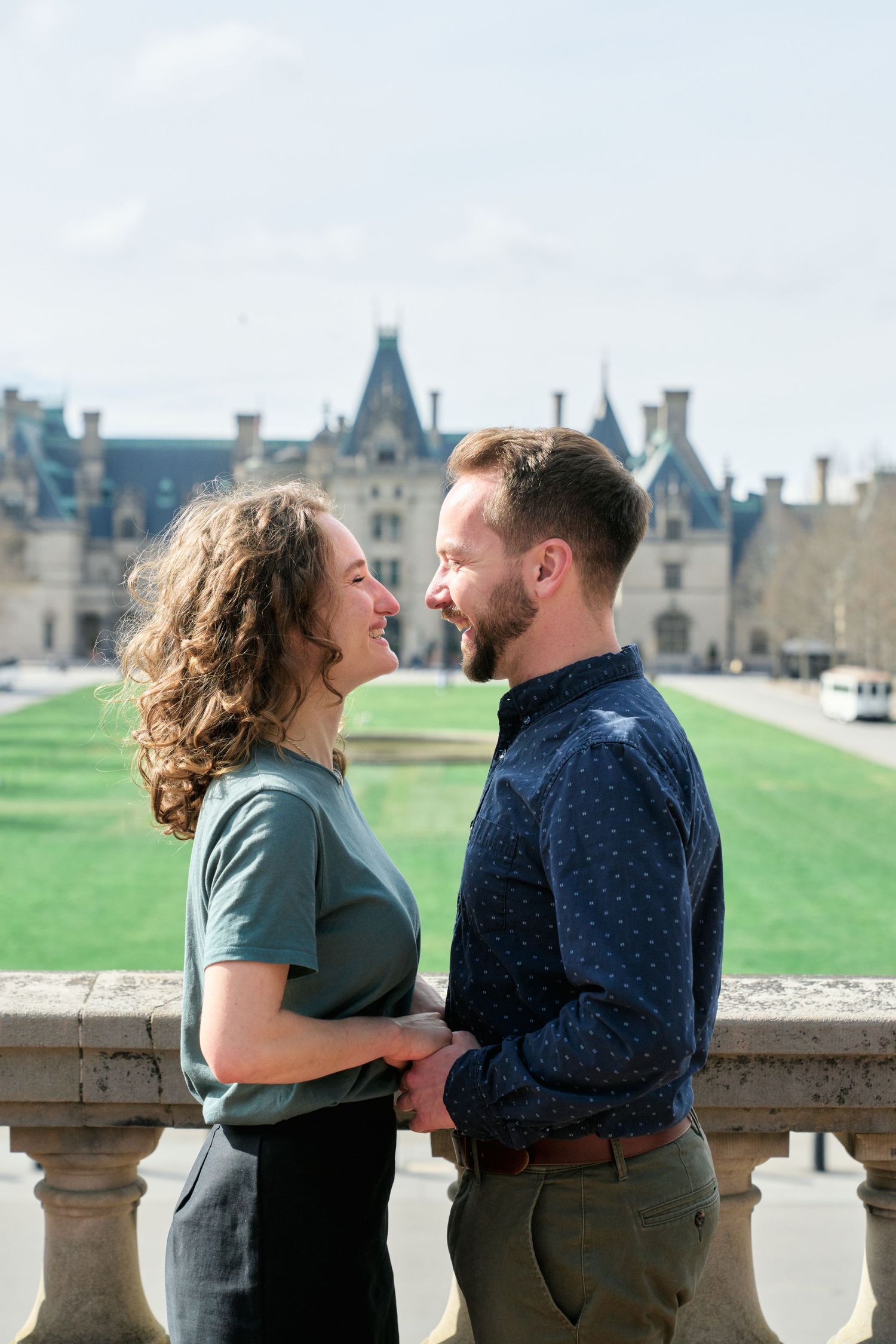 Couple kissing in from of the Biltmore Estate House during their engagement photos