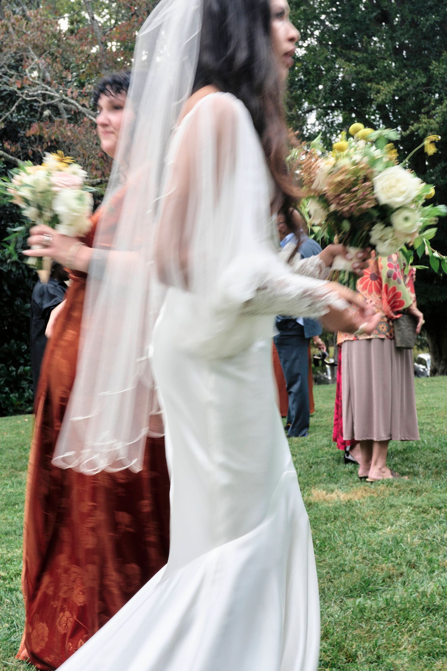 Blur photo of bride and flowers walking to her wedding reception.