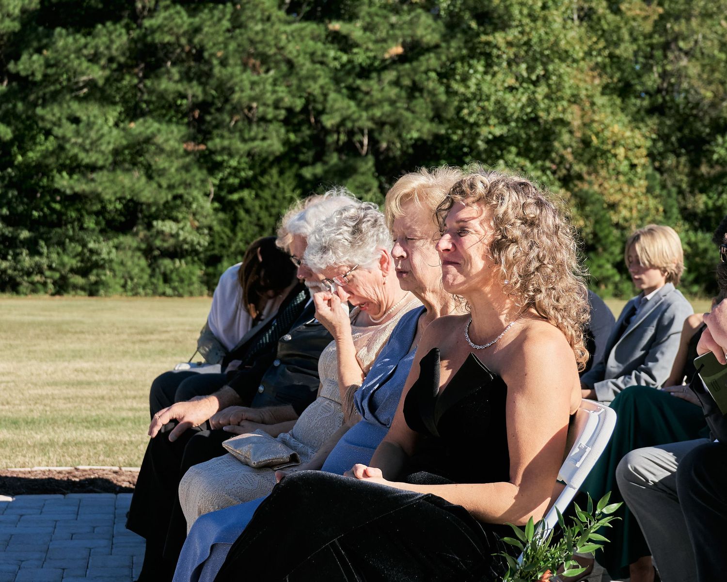 A couple shares an intimate moment while dancing together at an outdoor wedding celebration.