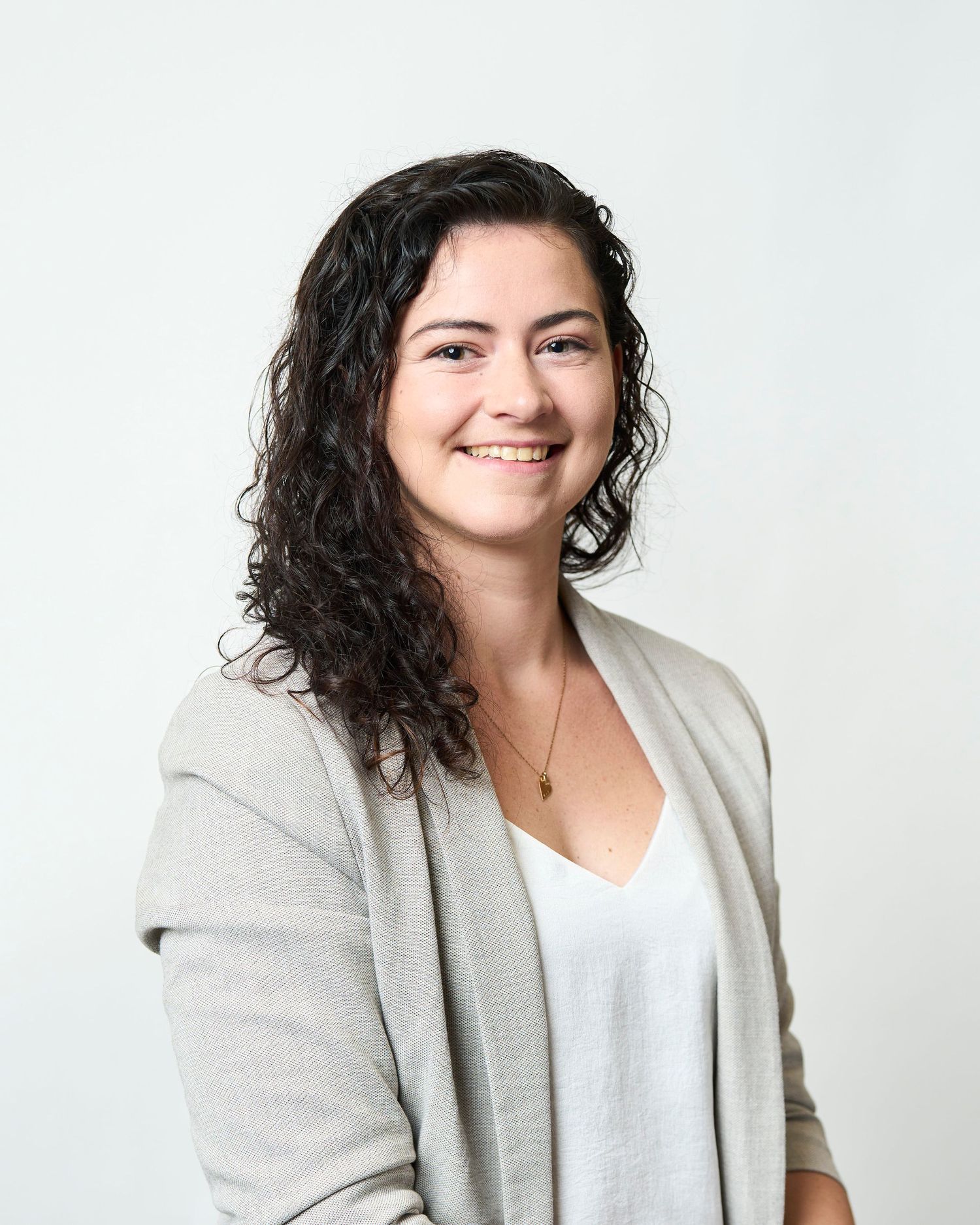 Professional headshot in Asheville, NC of a women sitting in front of a white background.