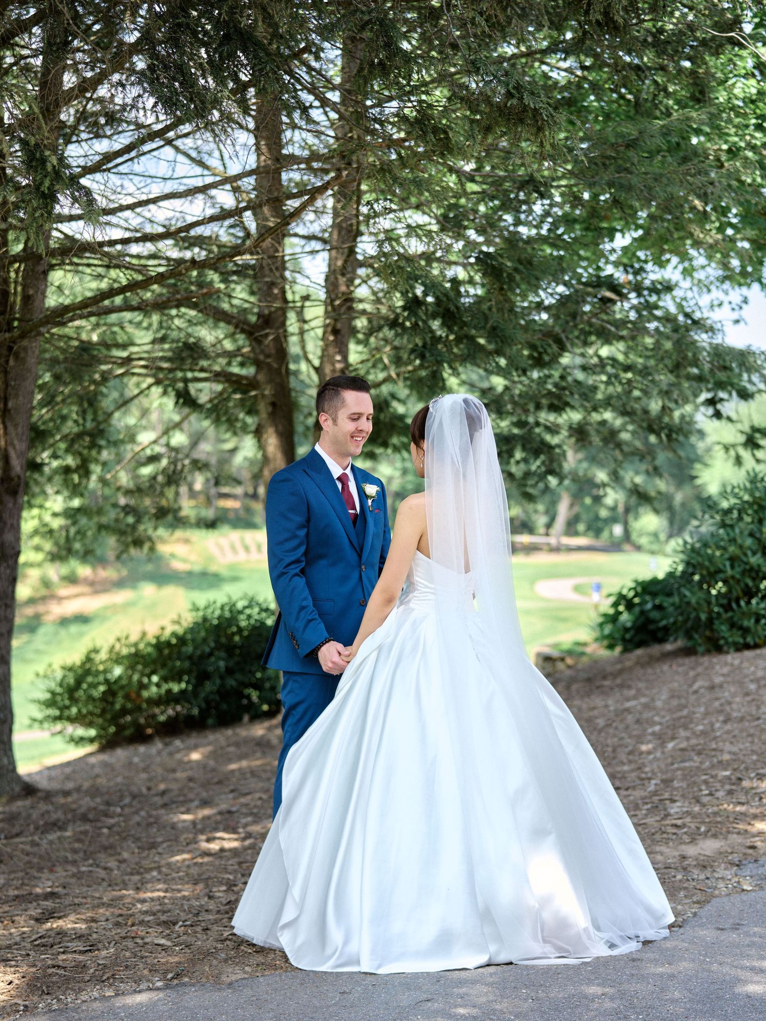 A couple shares a quiet moment among pine trees during their outdoor wedding photo session.