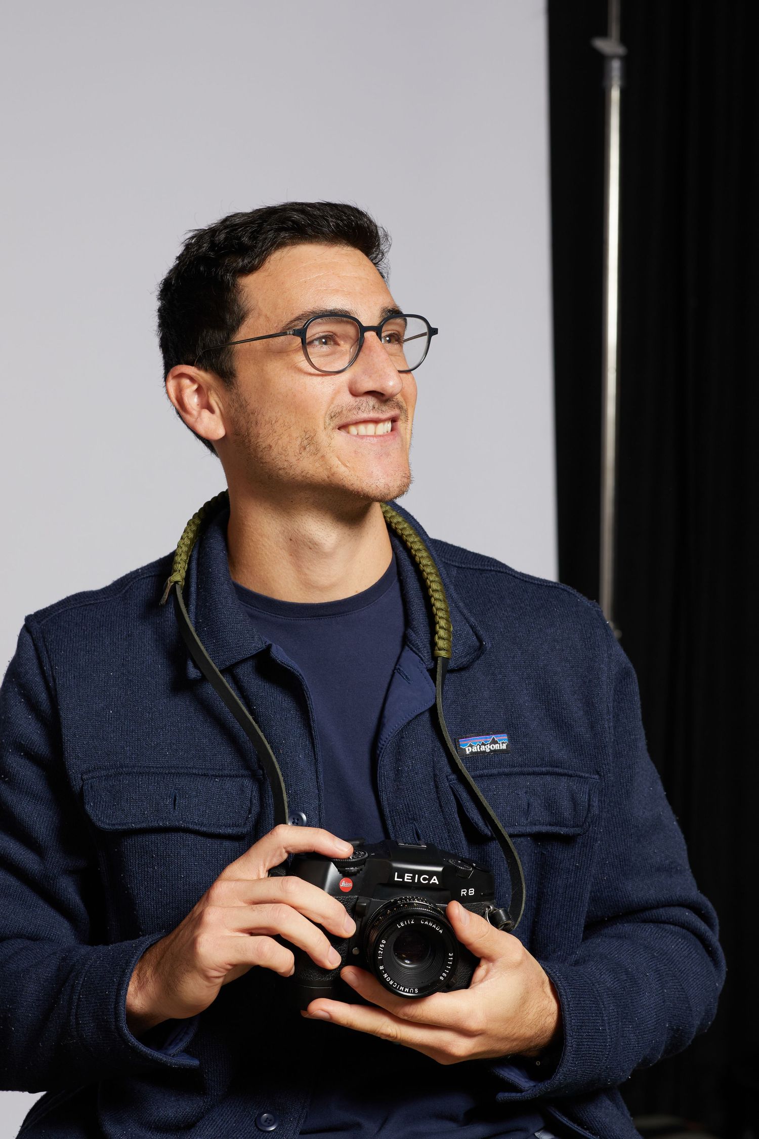 Professional Headshot photographer holding a camera in a studio
