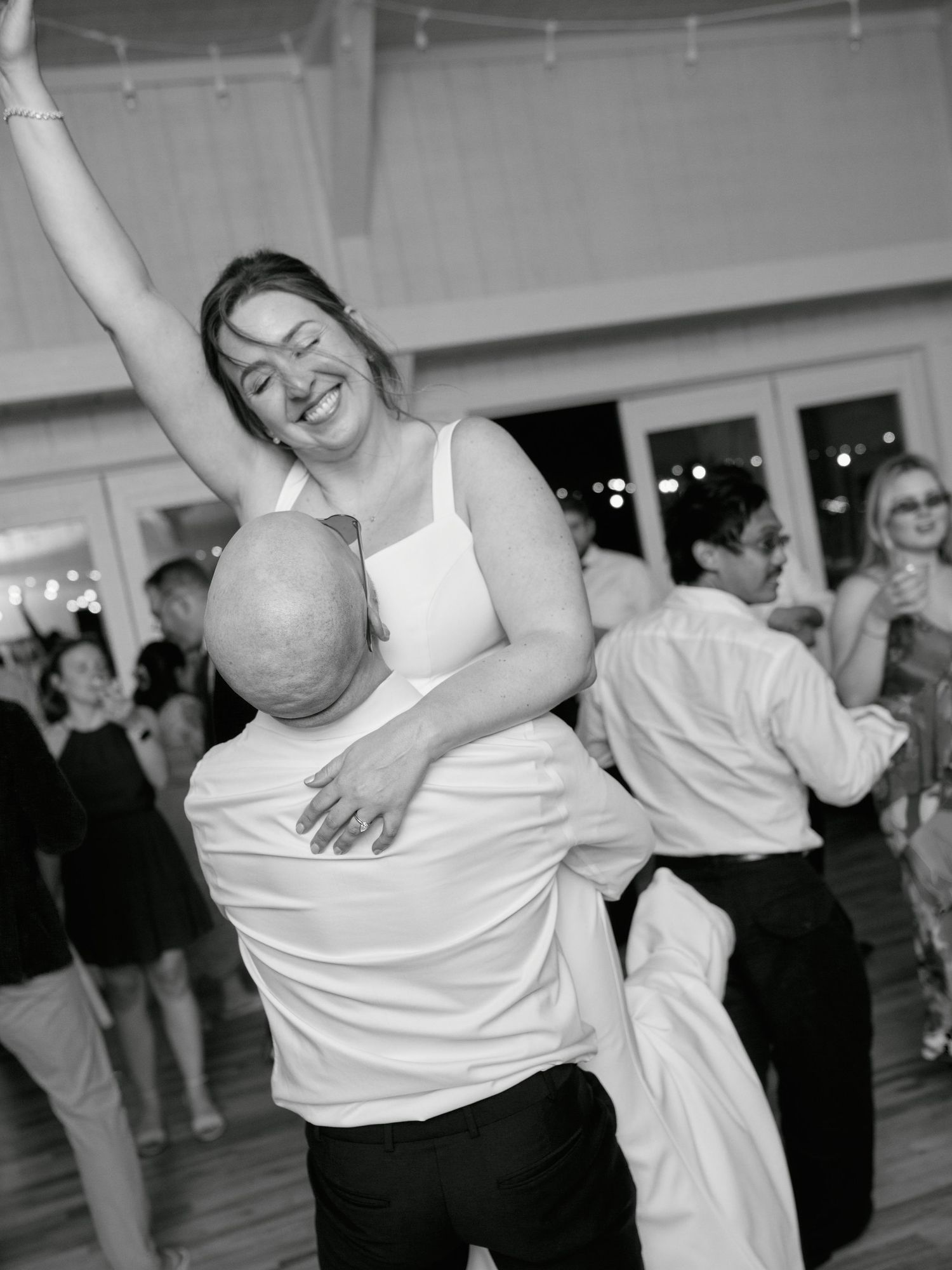 Dancers share a joyful moment during an energetic dance at an indoor event.