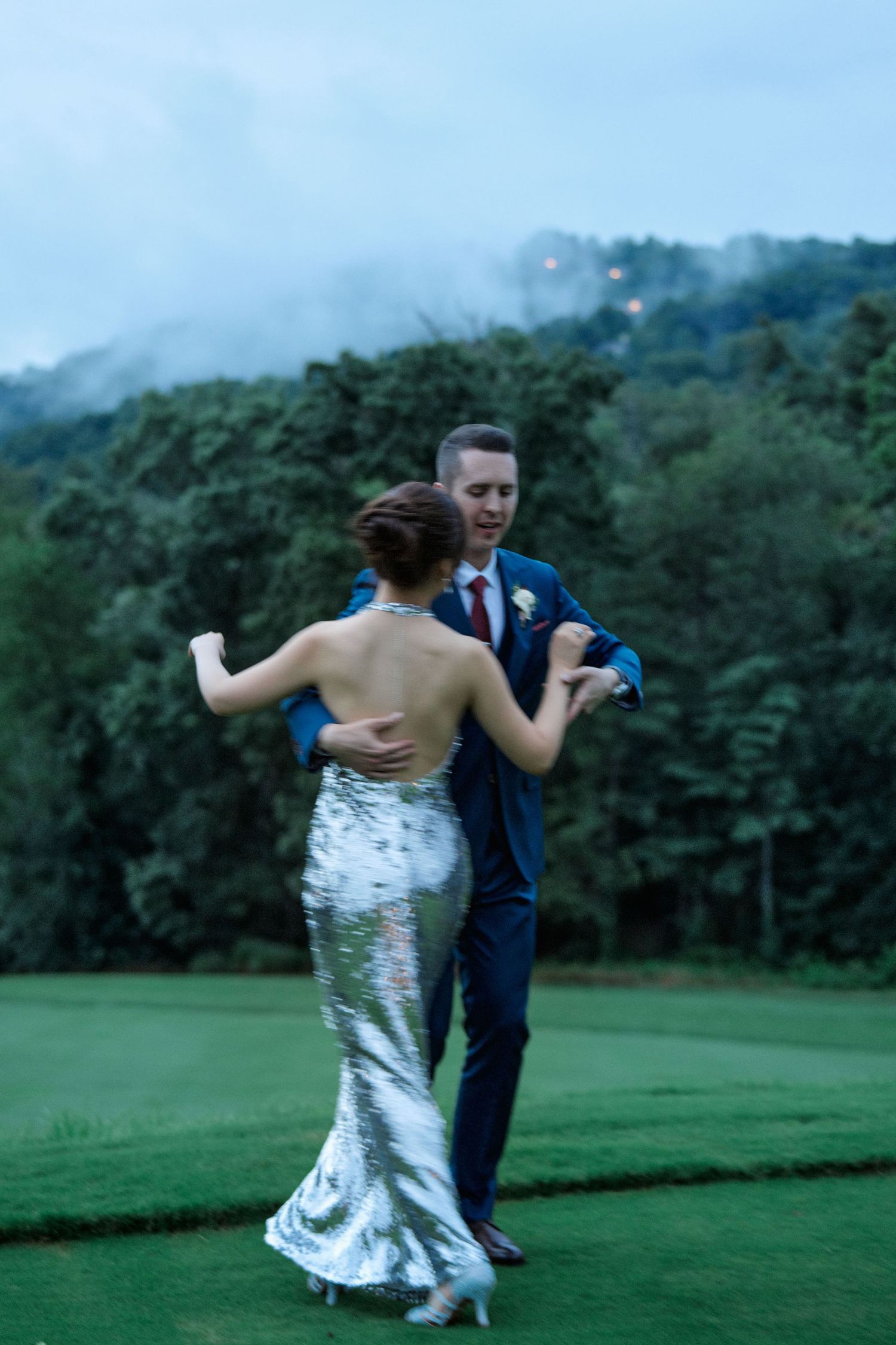 A couple dances on misty golf course grounds at twilight.