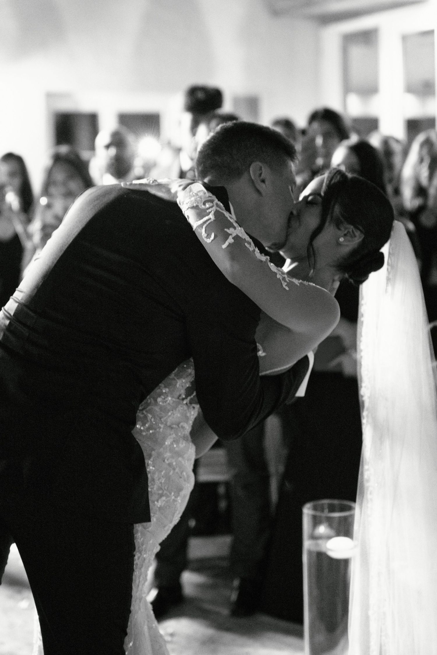 Romantic black and white photo of newlyweds sharing their first dance with dramatic dip.