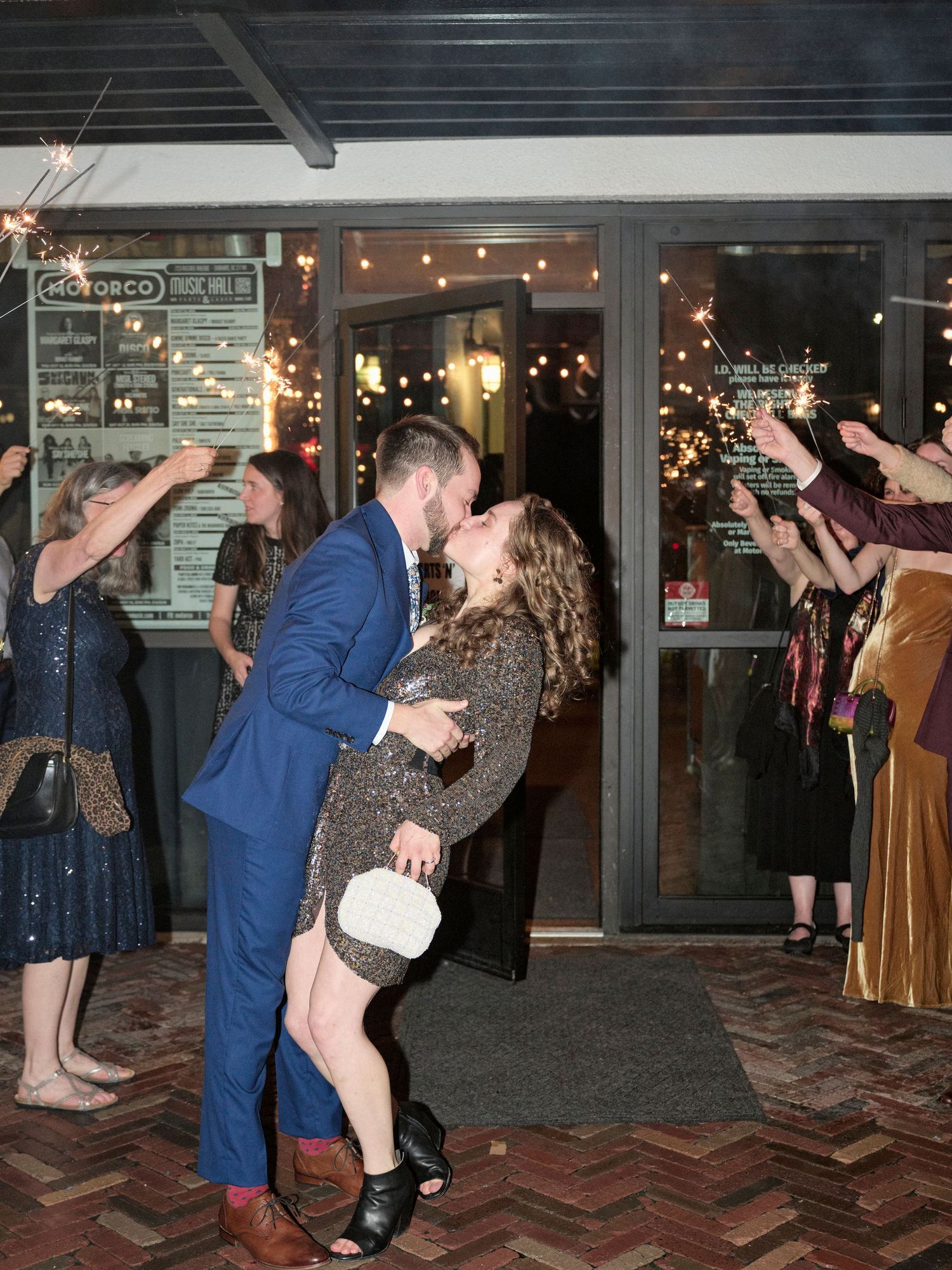 Guests celebrate with sparklers as a couple shares a romantic dance moment at an evening reception.