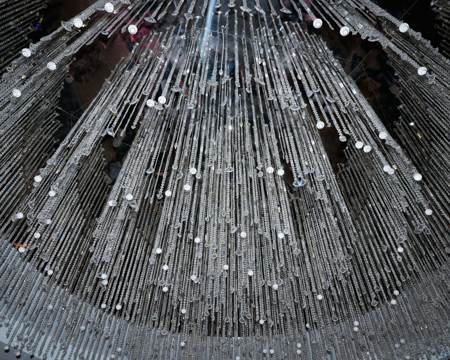 Abstract photo of steel rods arranged in a radial pattern with bright spots creating a dramatic starburst effect.