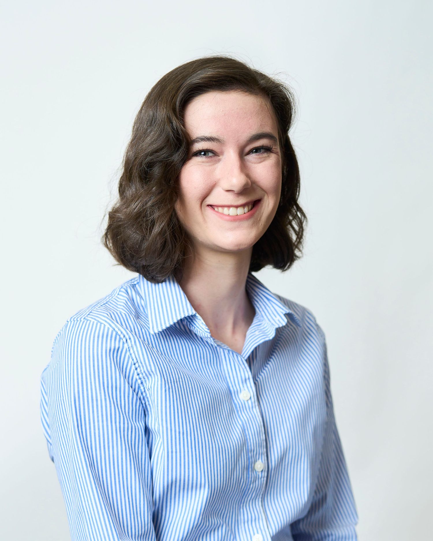 Professional headshot in Asheville, NC of a business women sitting in front of a white background.