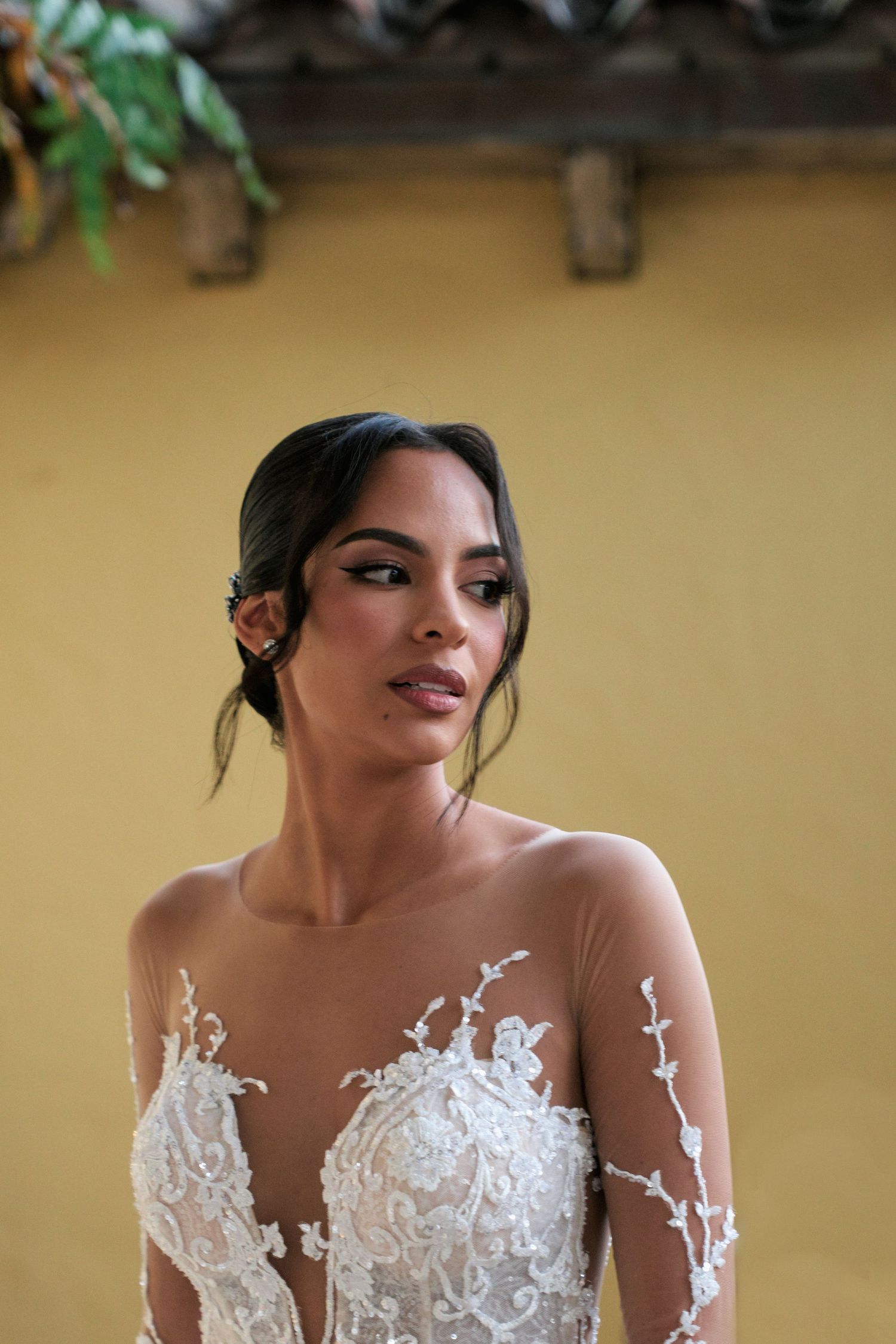 Beautiful wedding dress with intricate lace detailing and sheer illusion neckline captured in a bridal portrait.