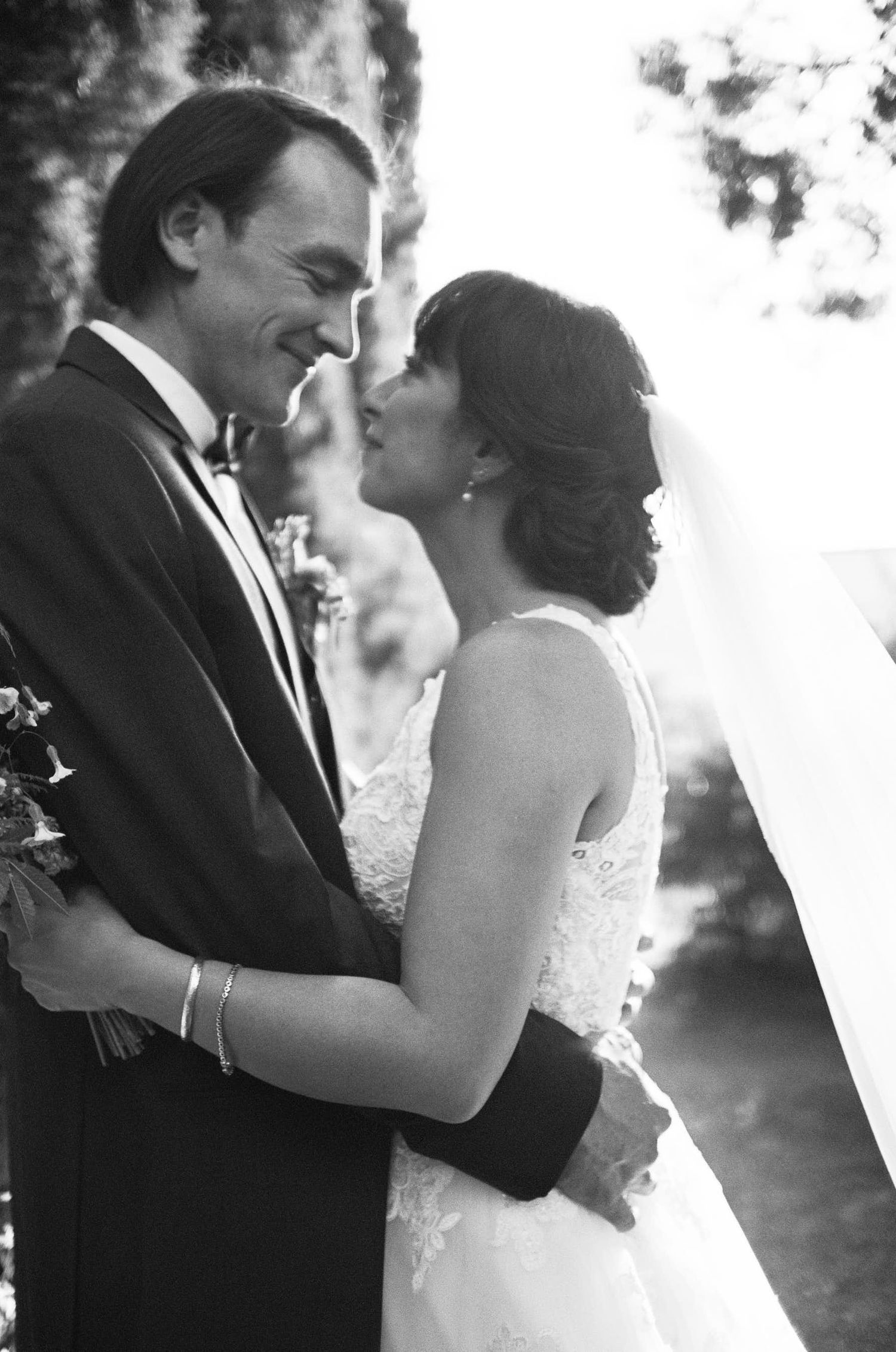 Intimate black and white portrait of newlyweds embracing during their wedding celebration.