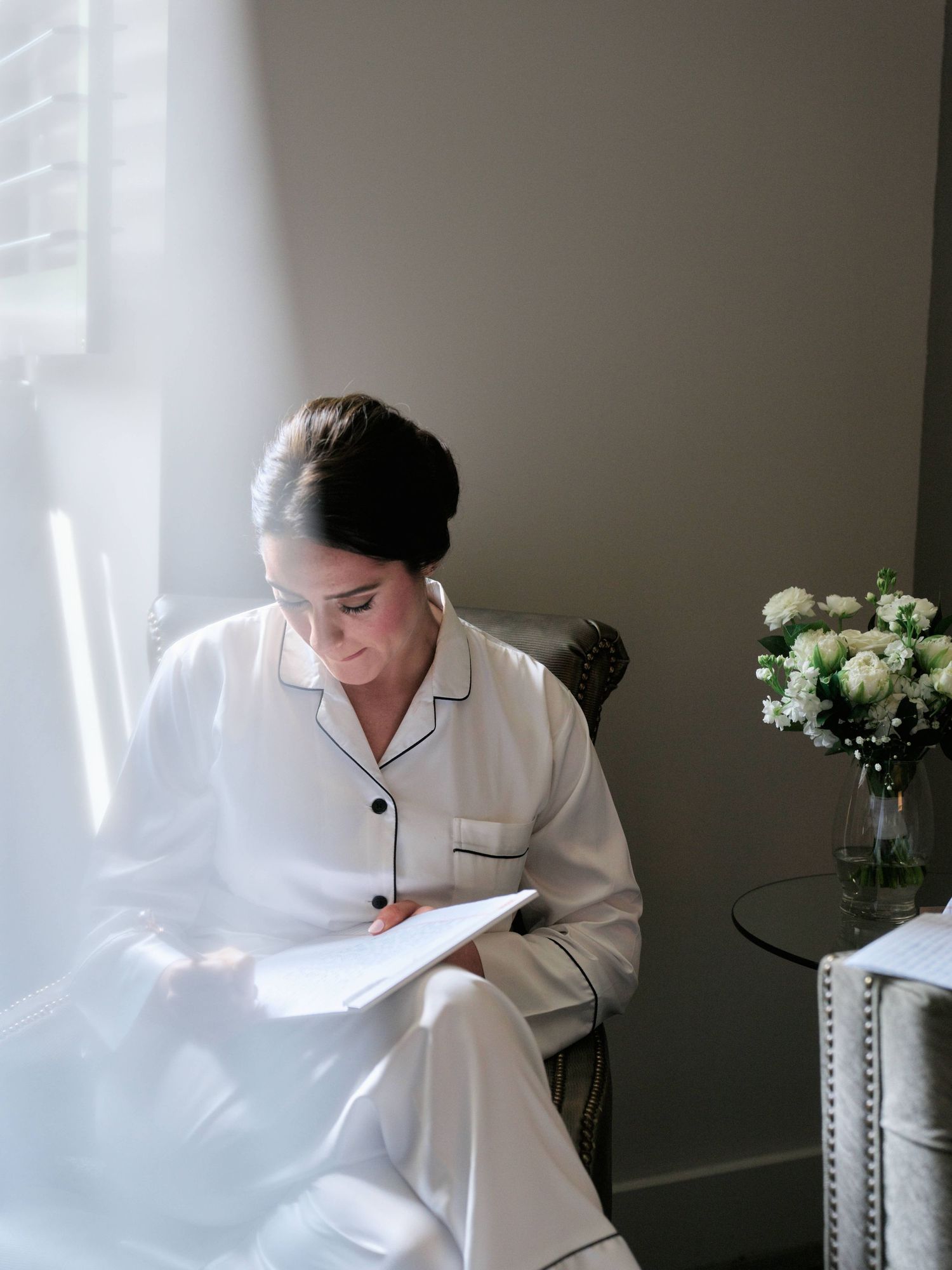 Bride waiting down writing down her vows before her wedding.