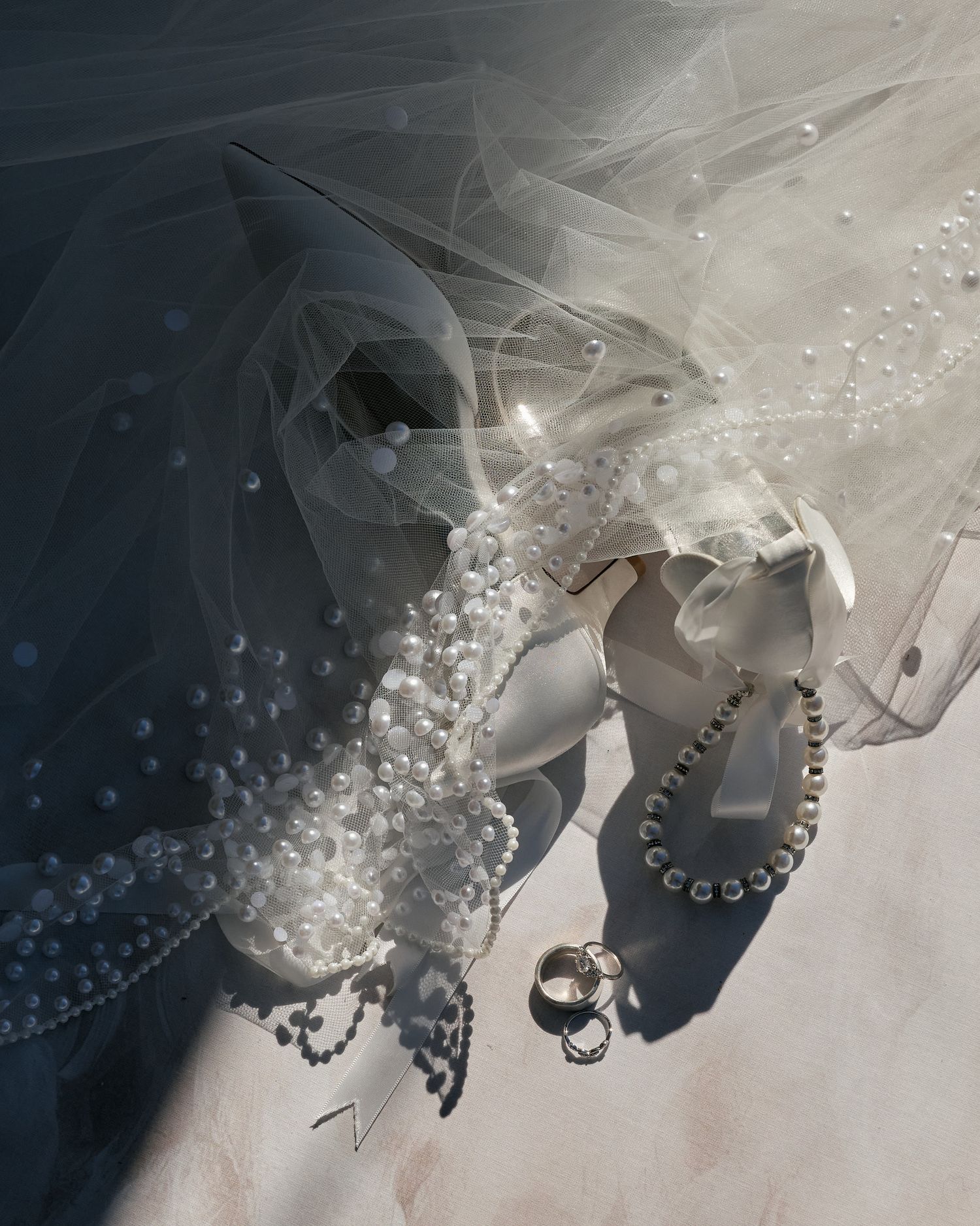 Close-up sequence of white tulle fabric with delicate pearl beading details creating an elegant bridal texture pattern.