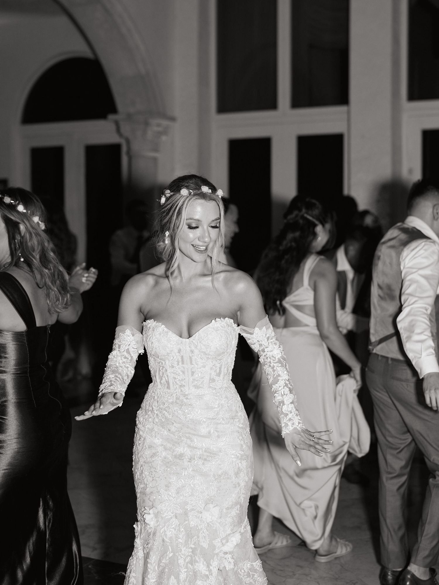 A bride in a lace wedding gown dances during the reception celebration.