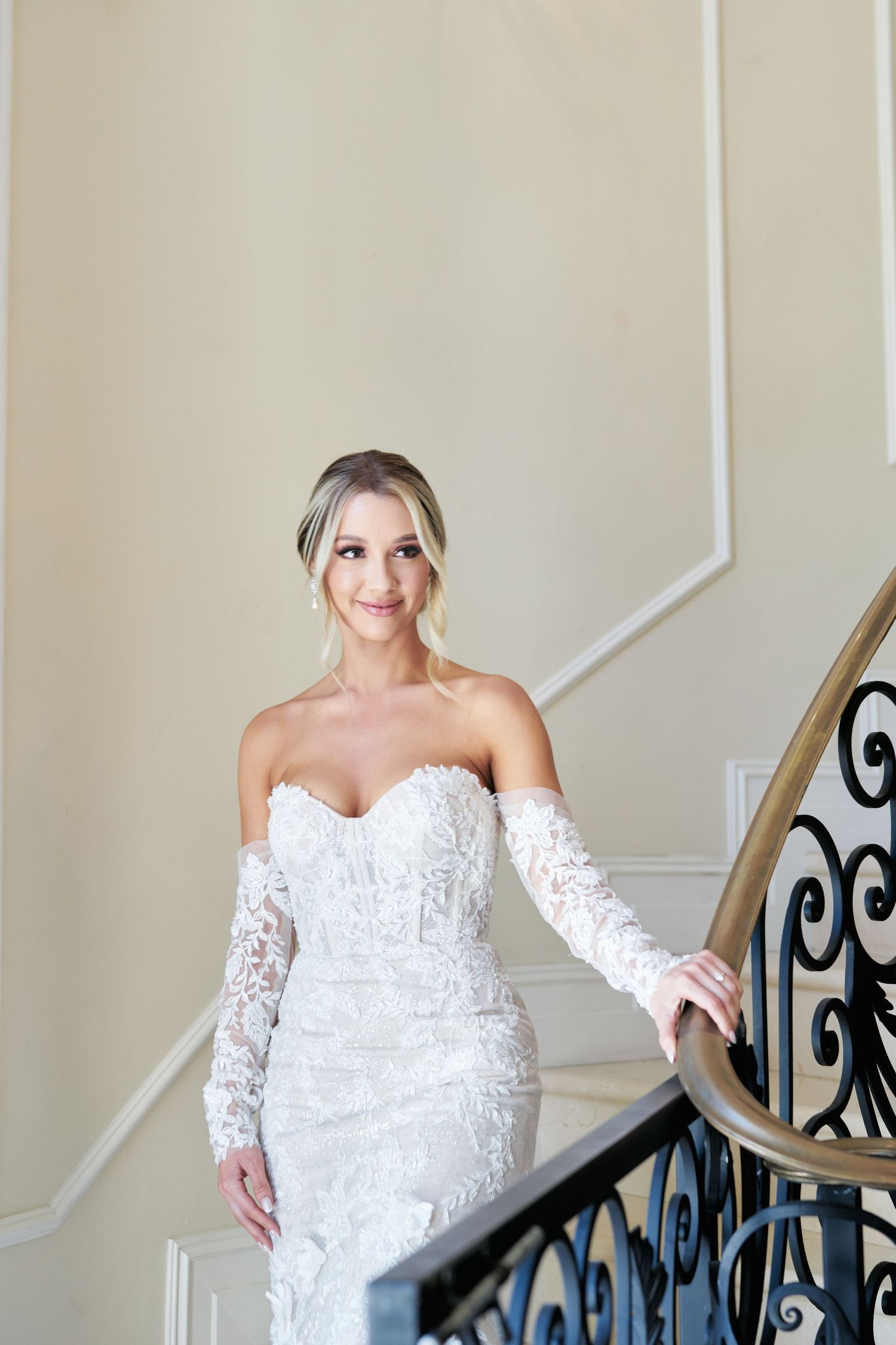 Beautiful bridal portrait on an elegant staircase with ornate iron railing.