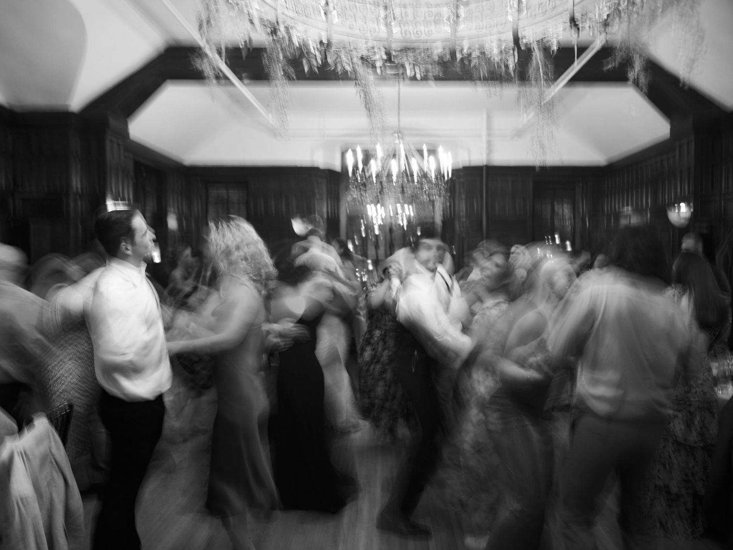 Black and white photo of couples dancing at an elegant ballroom event.