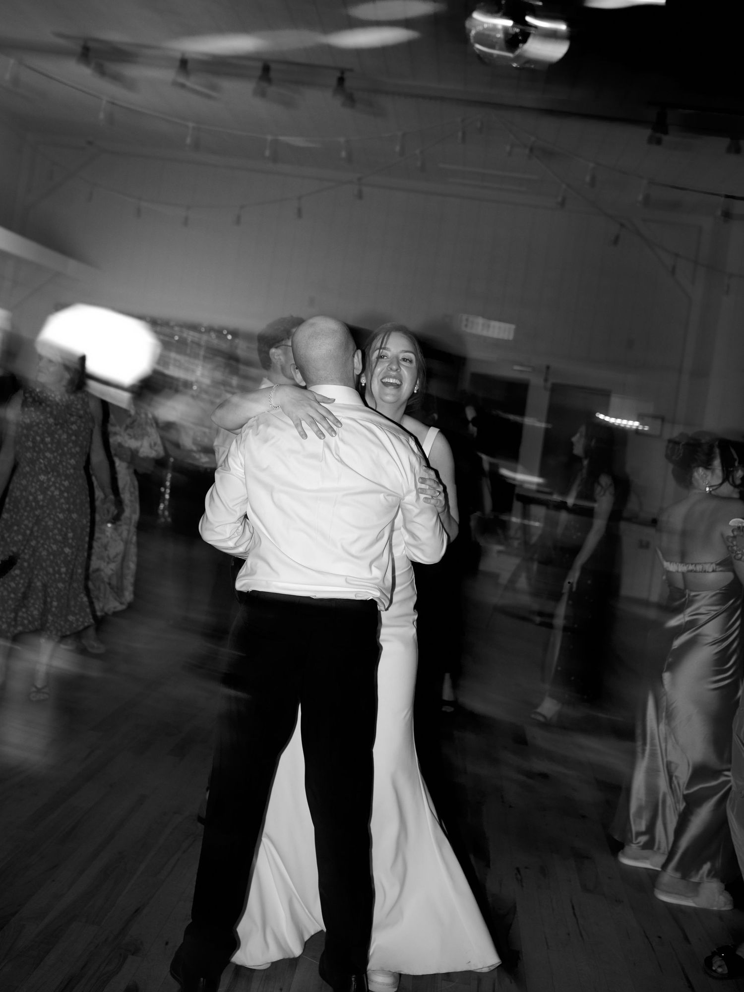 Black and white photo of dancing couples at a wedding reception.