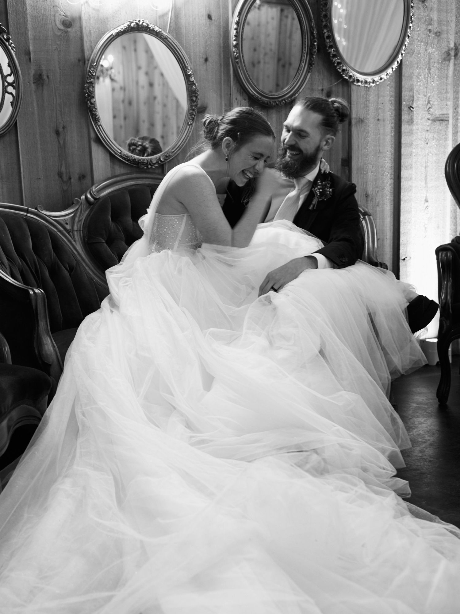 An intimate black and white portrait of a couple sharing a tender moment in a vintage room.